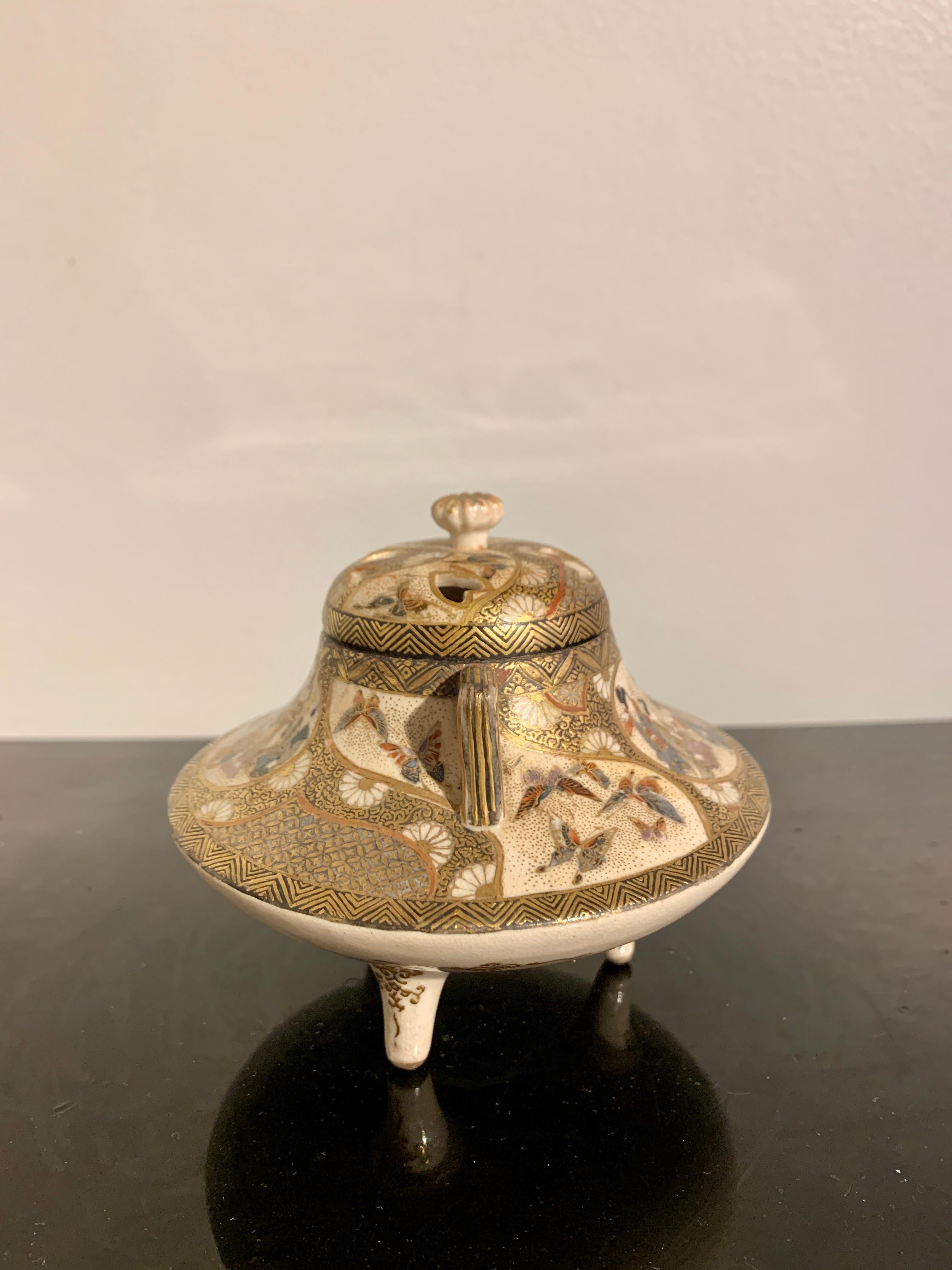 A small and finely decorated Japanese Satsuma tripod incense burner (koro), signed Kyozan, Meiji period, circa 1900, Japan.

The censer, koro, with a compressed body supported by three elegantly splayed legs. A pair of handles and a pierced cover