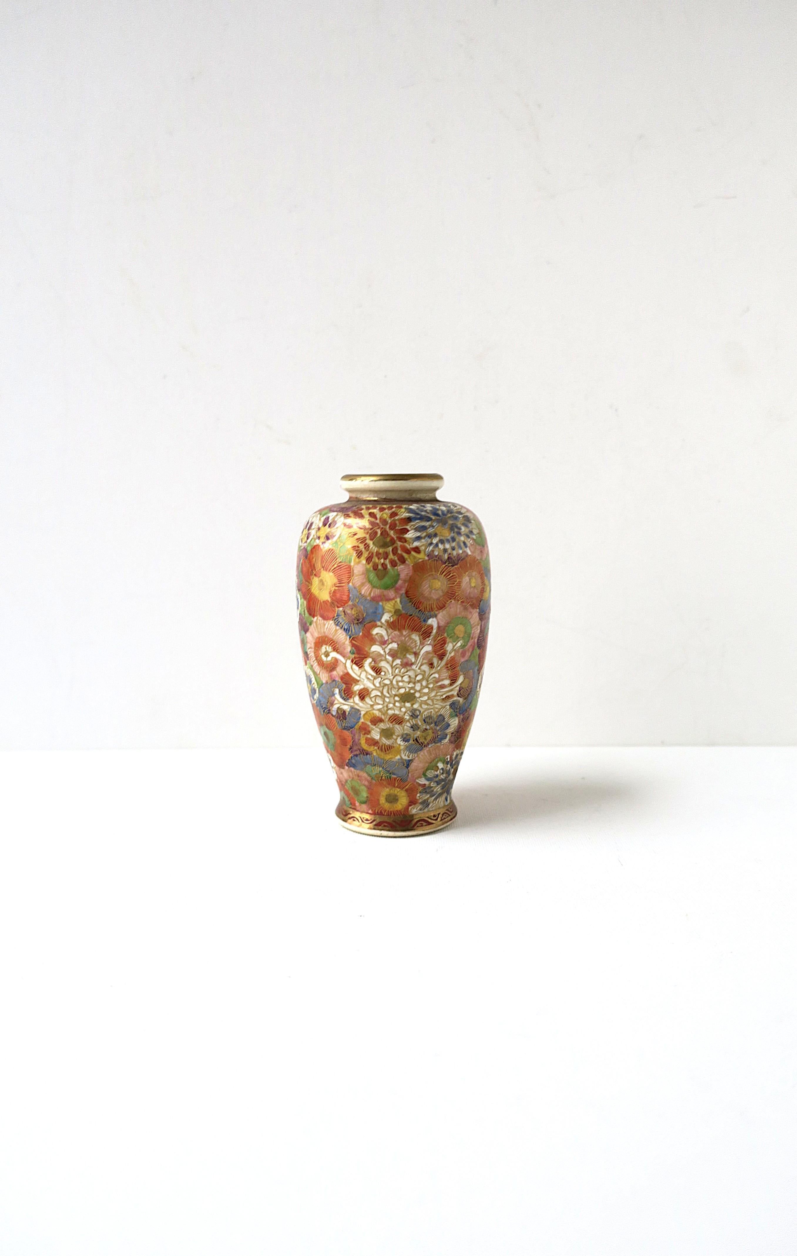 A gorgeous hand-painted Japanese Satsuma vase, Meigi, circa 20th century, Japan. Beautiful hand-painted detail of colorful flowers and spider mum flowers around finished with gold detail at top and base of this baluster shaped vase. With makers'