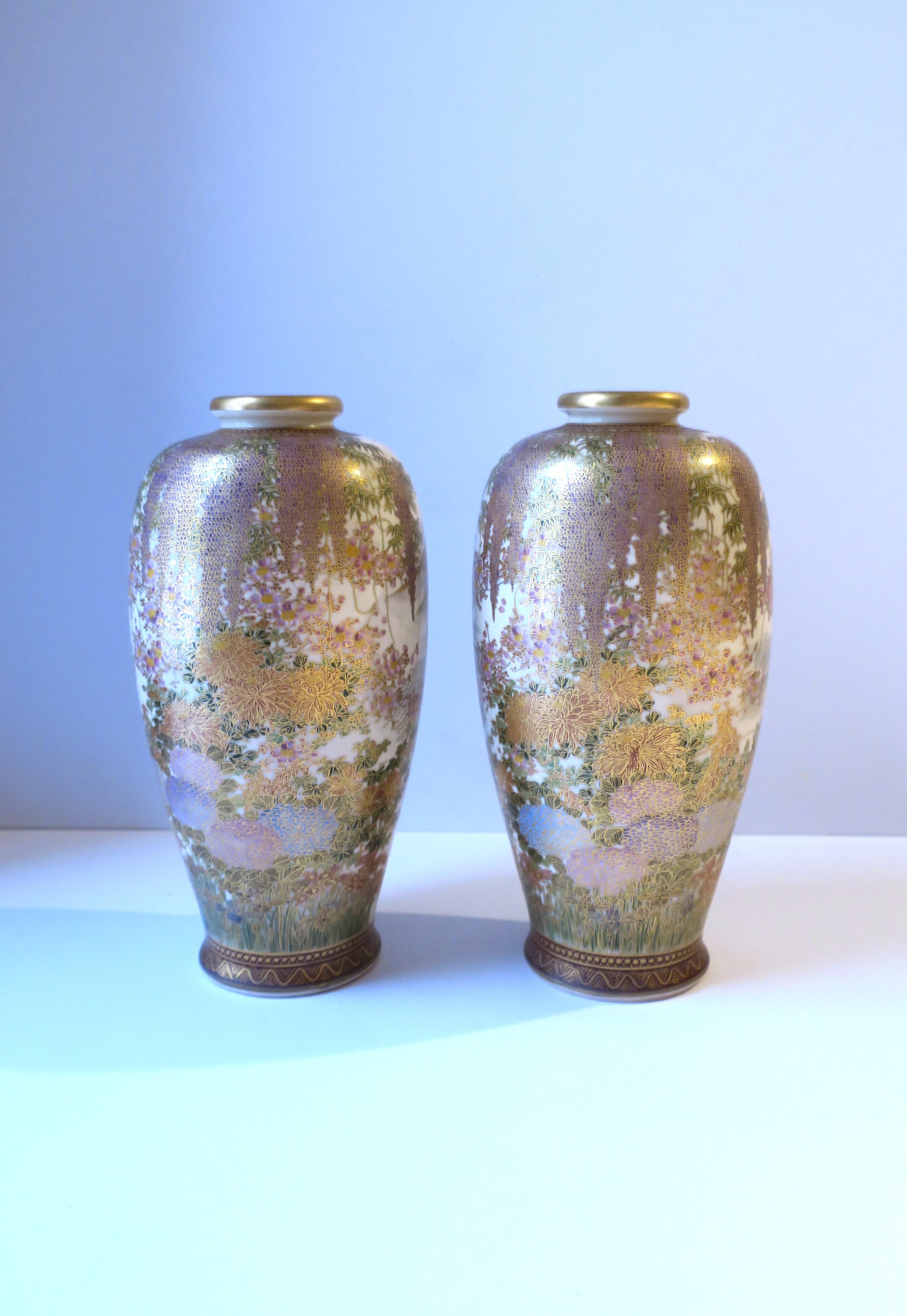 A gorgeous pair of Japanese earthenware Satsuma vases, hand-painted, Meiji period, circa early-20th century, Japan. Vases' beautiful decoration is high-quality and extremely detailed as shown. Color hues include gold gilt, pinks, purples, blues,