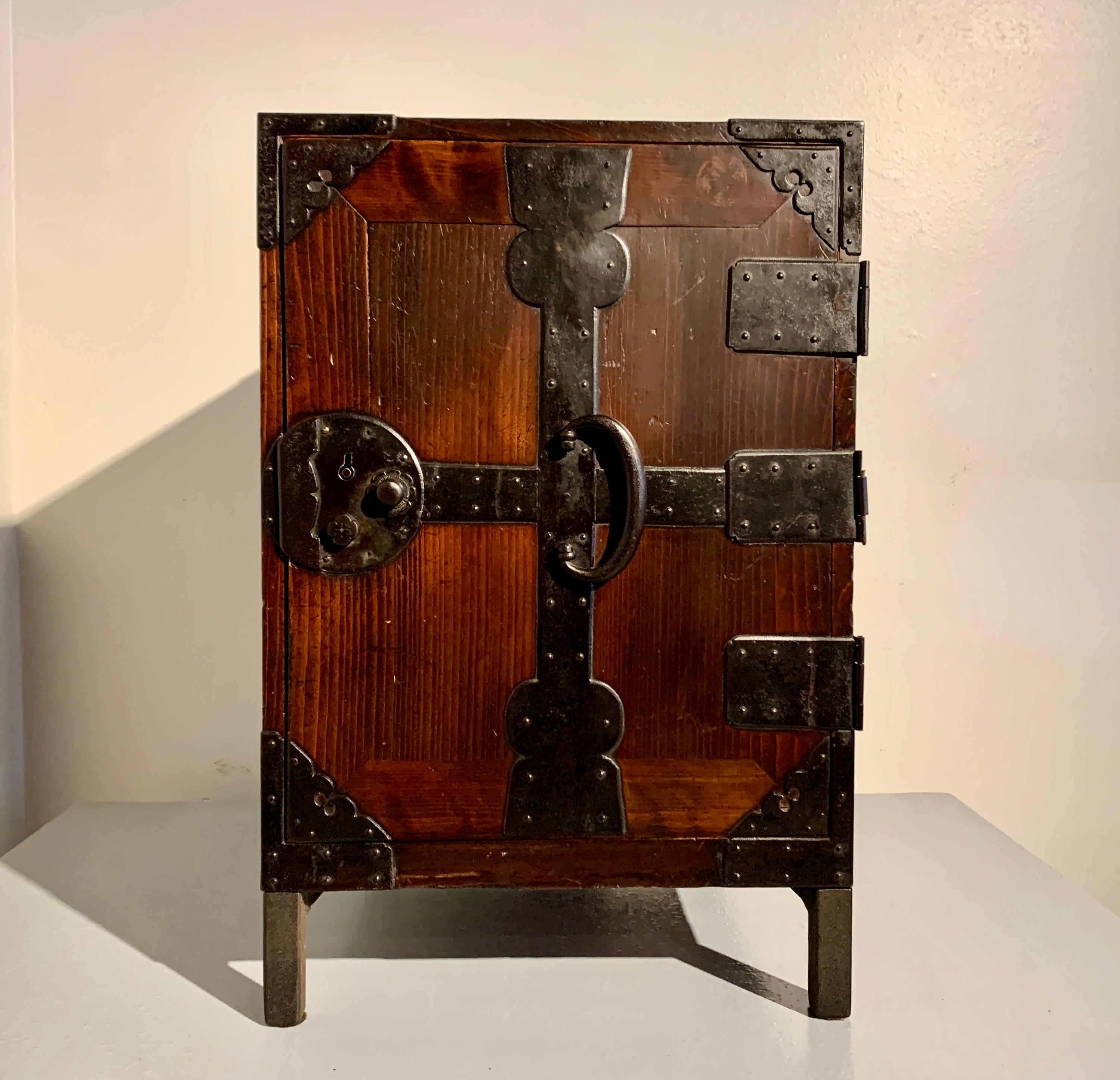 A simple and elegant Japanese sea chest, funa tansu, crafted of keyaki wood with iron fittings, mounted on a modern iron stand, Meiji Period, dated 1882, Japan.

This Japanese sea chest, or captain's chest, known as a funa tansu, features an