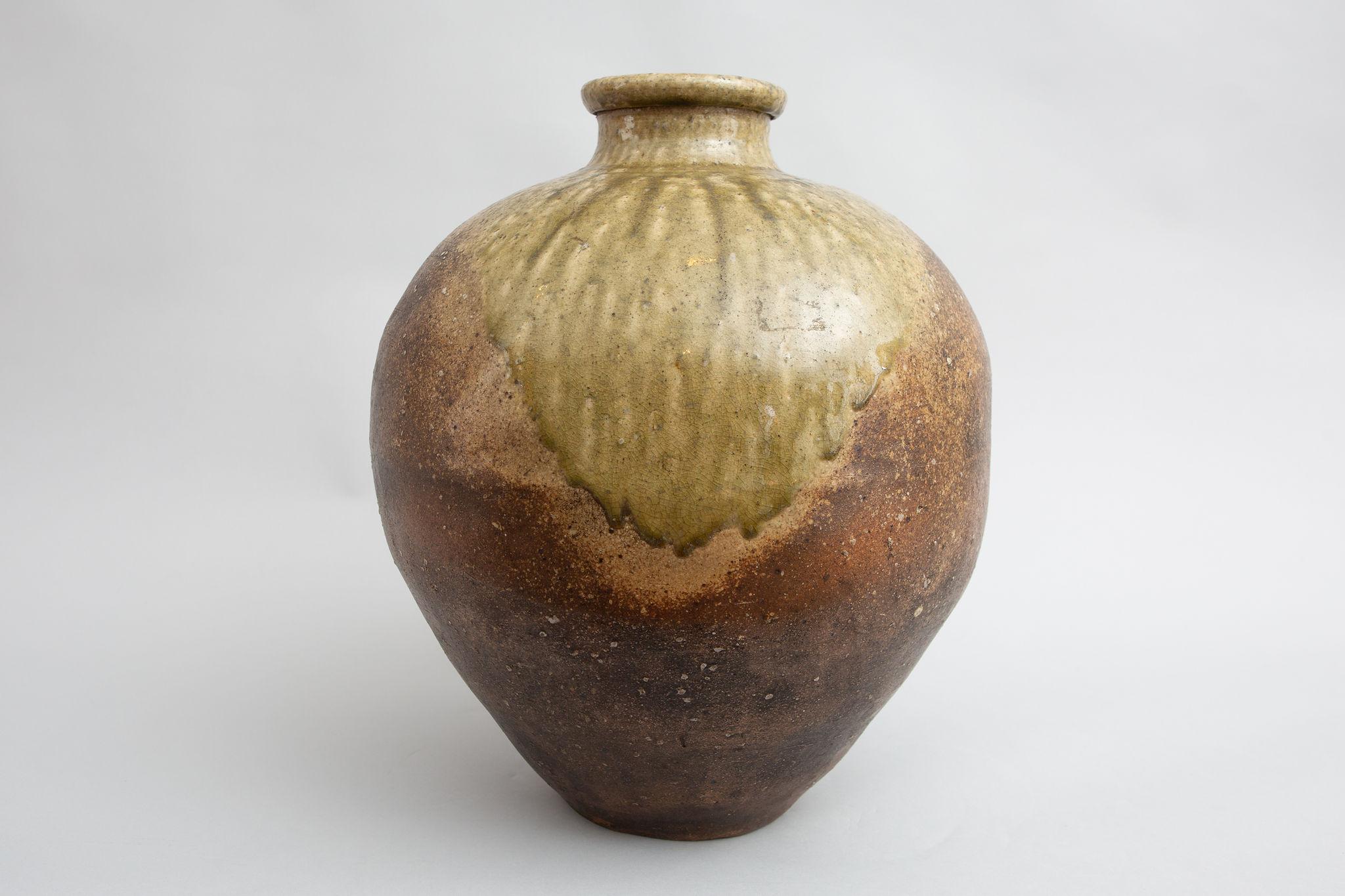 Shigaraki is one of the six ancient kilns of Japan. Early 17th century full formed vessel with refined neck and green glaze on front shoulder. Very similar to two pieces in 