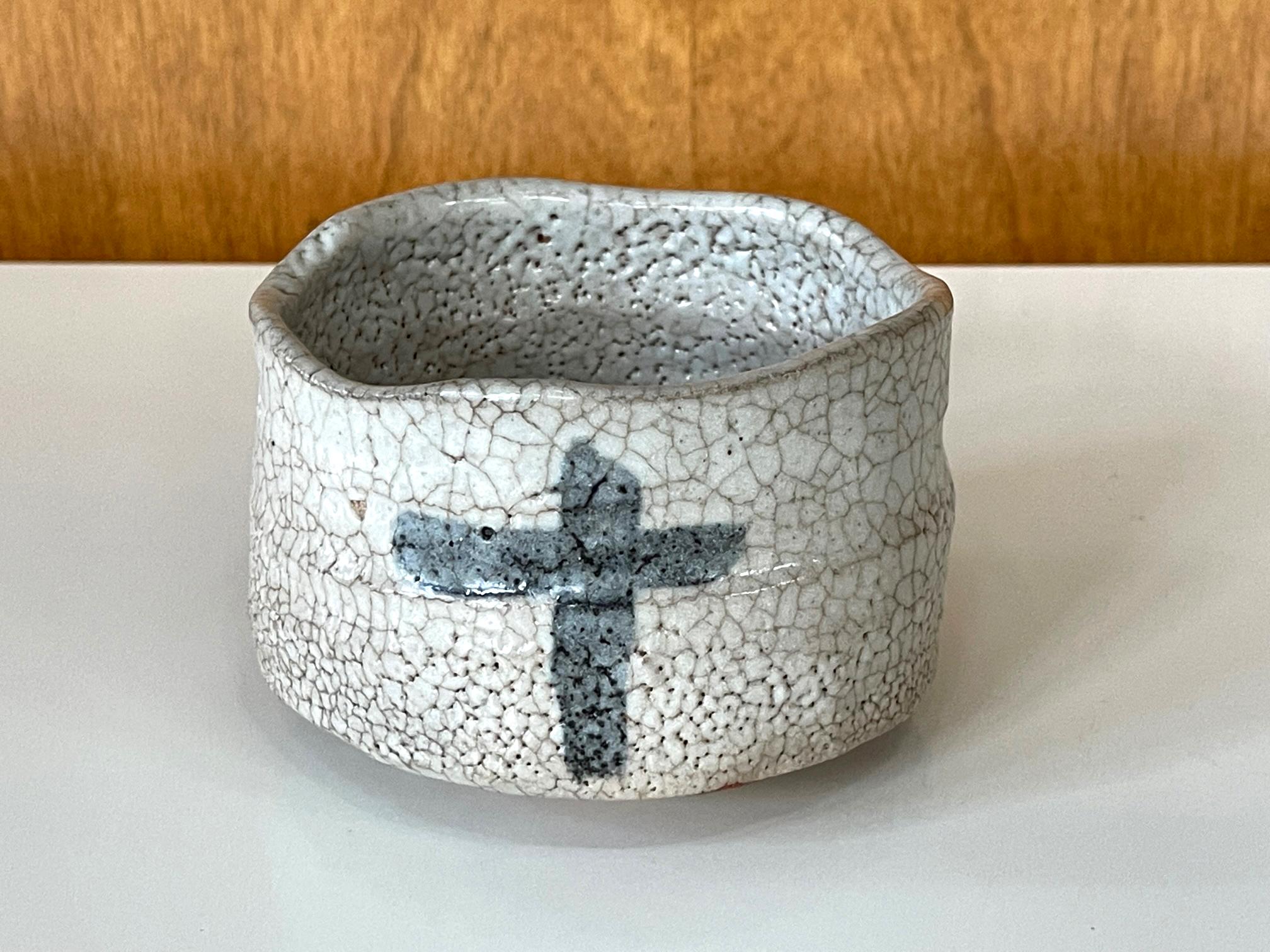 Eine moderne japanische Teeschale (Chawan) aus Keramik des Töpfers Toyoda Katsuhiko (1945-). Die Schale wurde in der Tradition der Shino-Ware in Klumpenform mit einem kurzen Ringfuß getöpfert. Dank seiner Größe und harmonischen Proportionen kann er