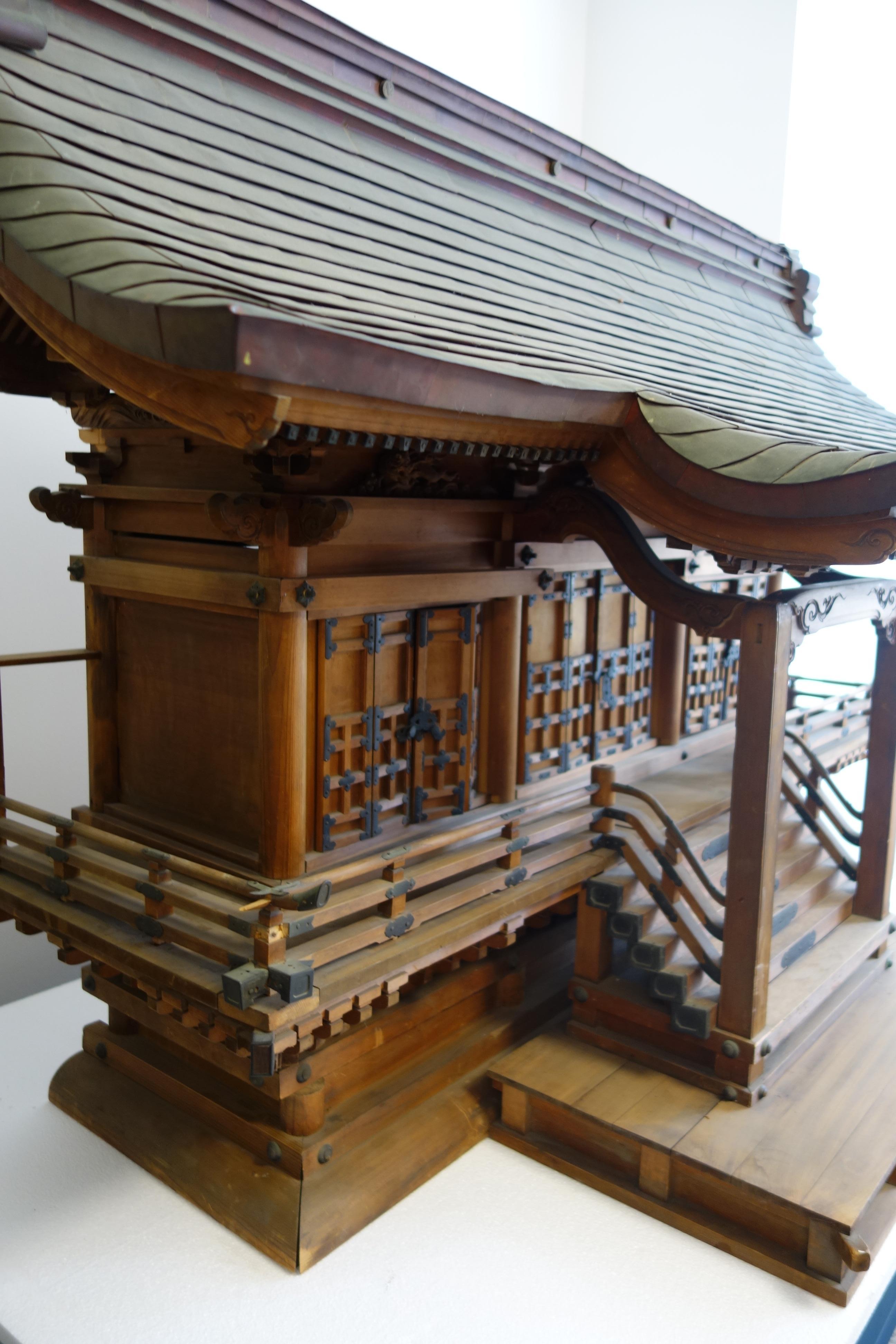 This beautiful Shinto Shrine is called ´Yamako´ and represents a Japanese antique house altar. It is very elaborately carved by hand and decorated with metal fittings. The roof is covered with copper plates and decorated with beautiful Japanese
