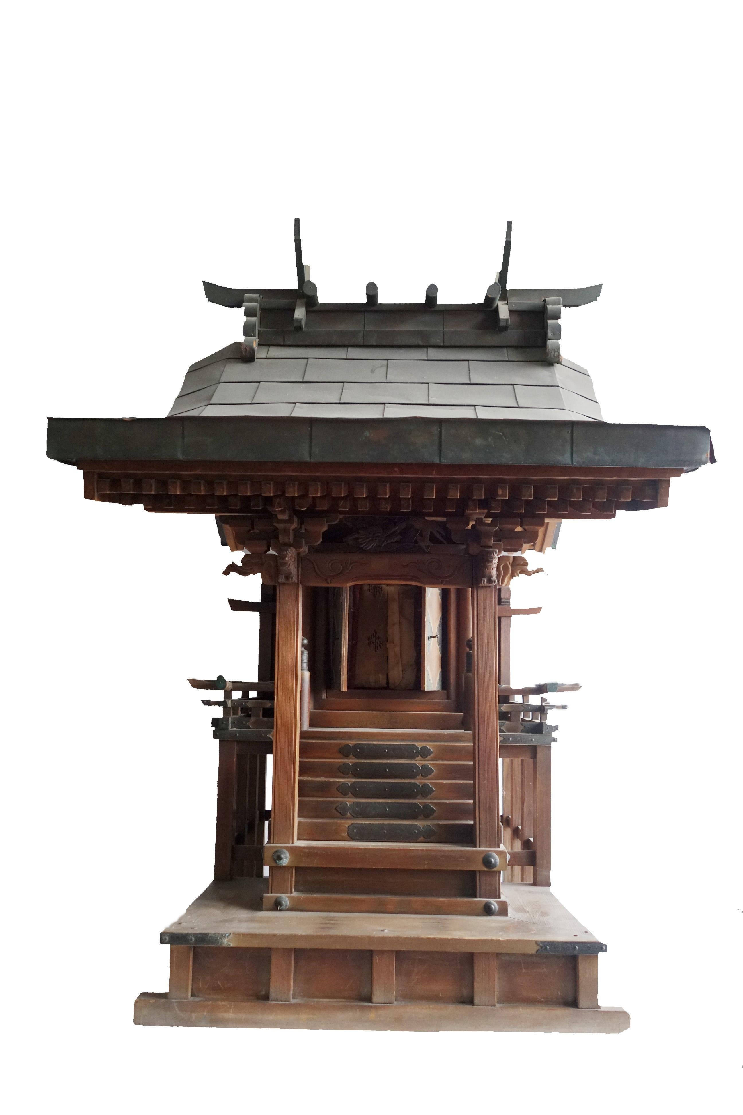 This beautiful Shinto Shrine is called ´Yamako´ and represents a Japanese antique house altar. It is very elaborately carved by hand and decorated with metal fittings. The roof is covered with copper plates and decorated with beautiful Japanese