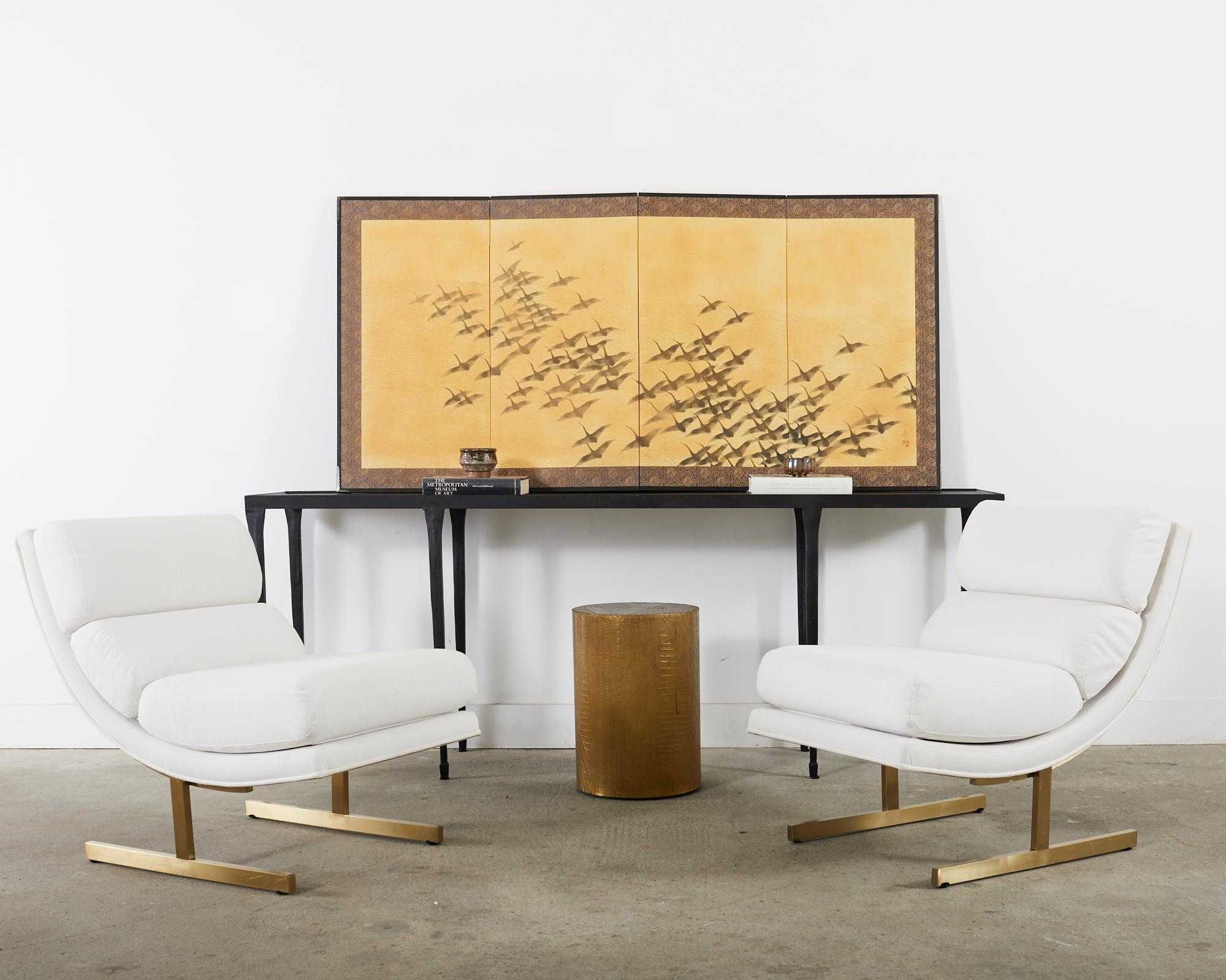 Impressive modern style Japanese Showa period four panel byobu screen depicting a flock of wild geese in flight over a stylized background. Delicate ink pigments over hand-crafted mulberry paper in a golden color. The screen is set in a wood frame