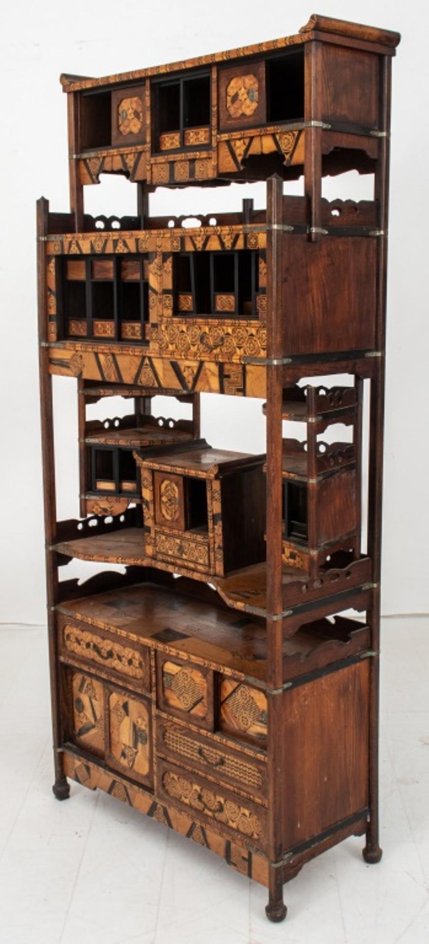 Japanese marquetry shadona etagere, Showa period, 1920's with elaborate architectural style geometric inlay and metal mounts, in the form of a curio-bookcase cabinet with sliding doors, shelves, and hinged brackets.

Dimensions:   67.5