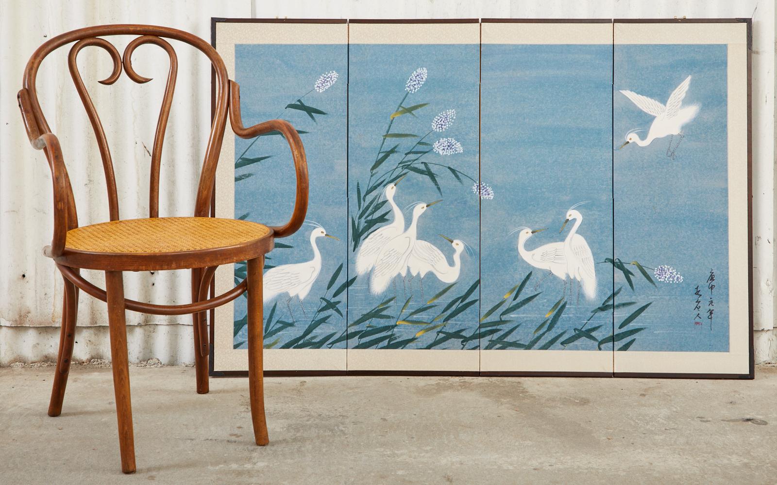 Delightful Japanese Showa period four-panel byobu screen. Depicting a siege of white herons in an idyllic blue landscape. Ink and color pigments on paper set in a lacquered wood frame with a silk cream colored border. The beautiful white birds