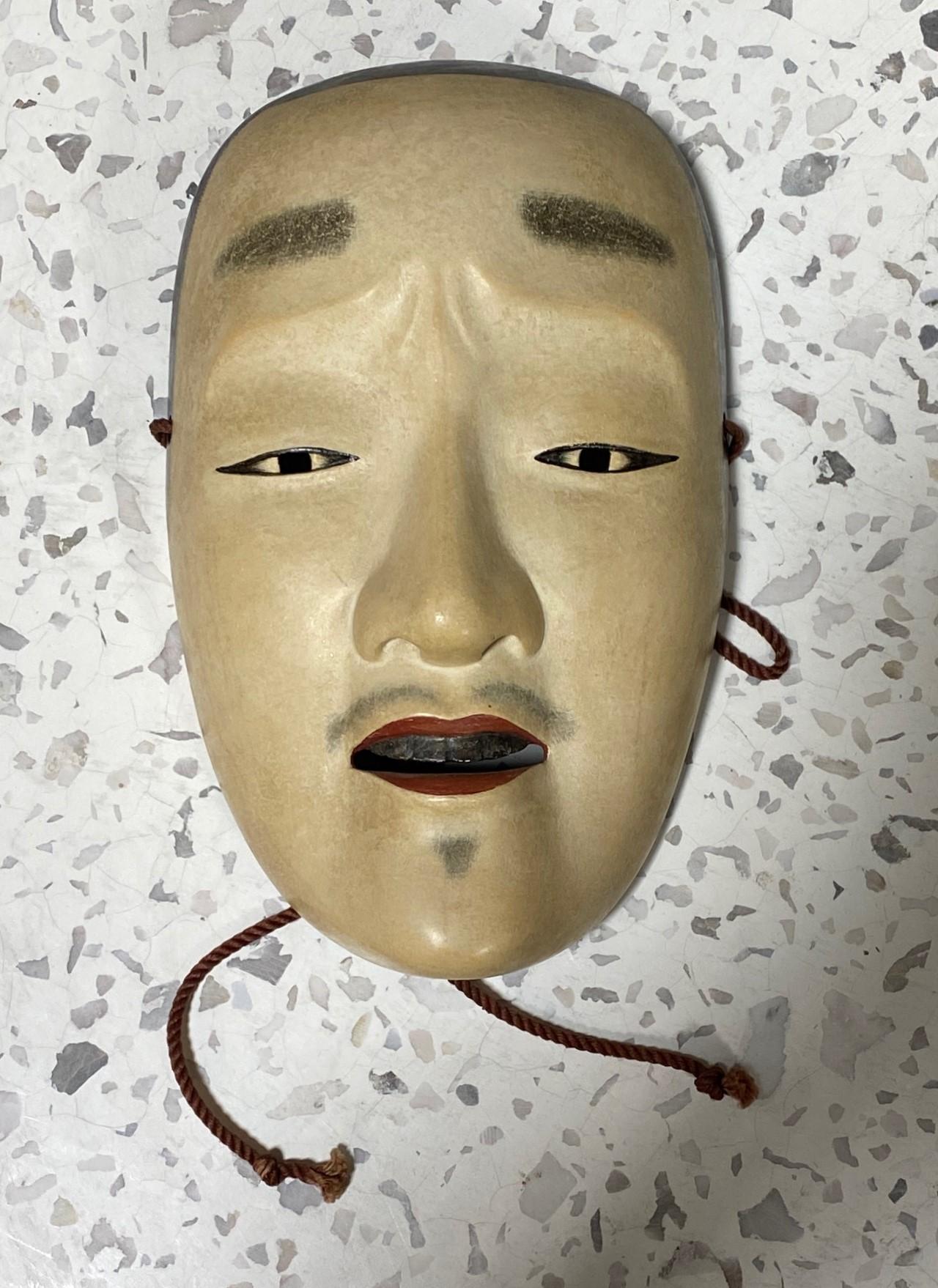Eine wunderschöne, wunderbar gearbeitete, verführerische Maske, die für das japanische Noh-Theater hergestellt wurde.

Die Maske ist handgefertigt und handgeschnitzt aus Naturholz und ist auf der Rückseite vom Hersteller, der offensichtlich ein