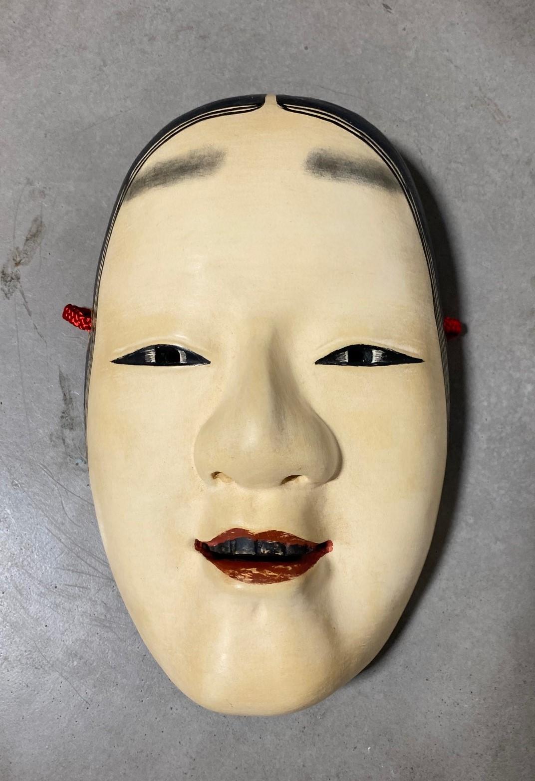 Eine wunderschöne, wunderbar gearbeitete, verführerische Maske, die für das japanische Noh-Theater hergestellt wurde.

Diese Maske ist handgefertigt und handgeschnitzt aus Naturholz und auf der Unterseite vom Hersteller signiert/versiegelt.