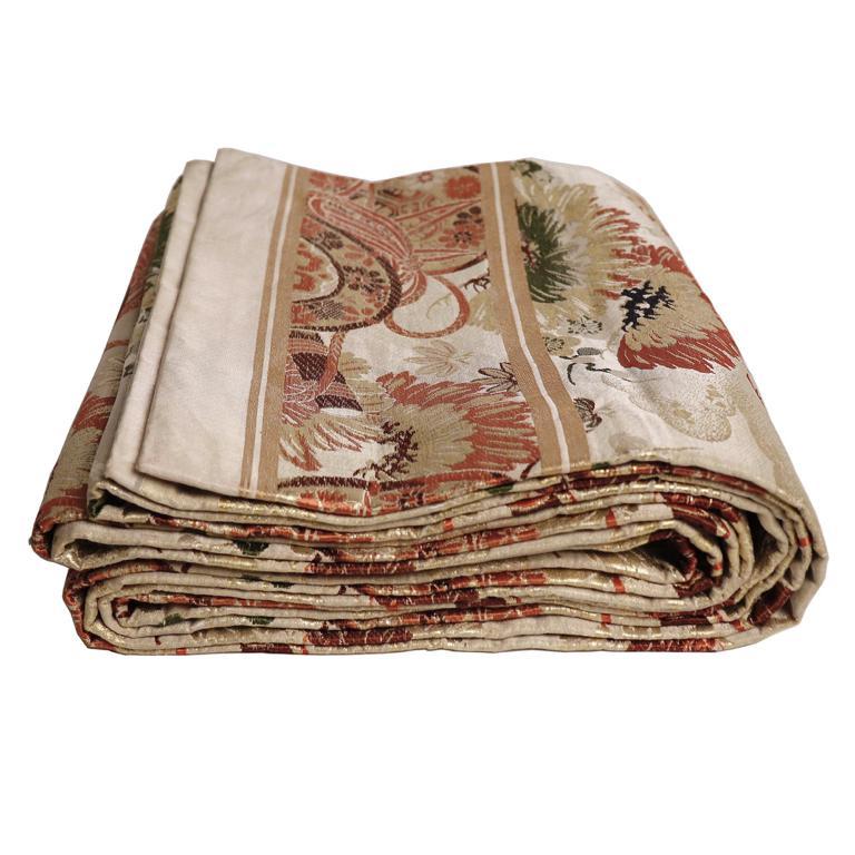 Japanese silk brocade maru obi, used as a sash for the kimono, a single piece folded in half and interior lining, the pattern a golden white background with large repeat design of a palanquin, drum, flute, pine and prunus rendered in various colors