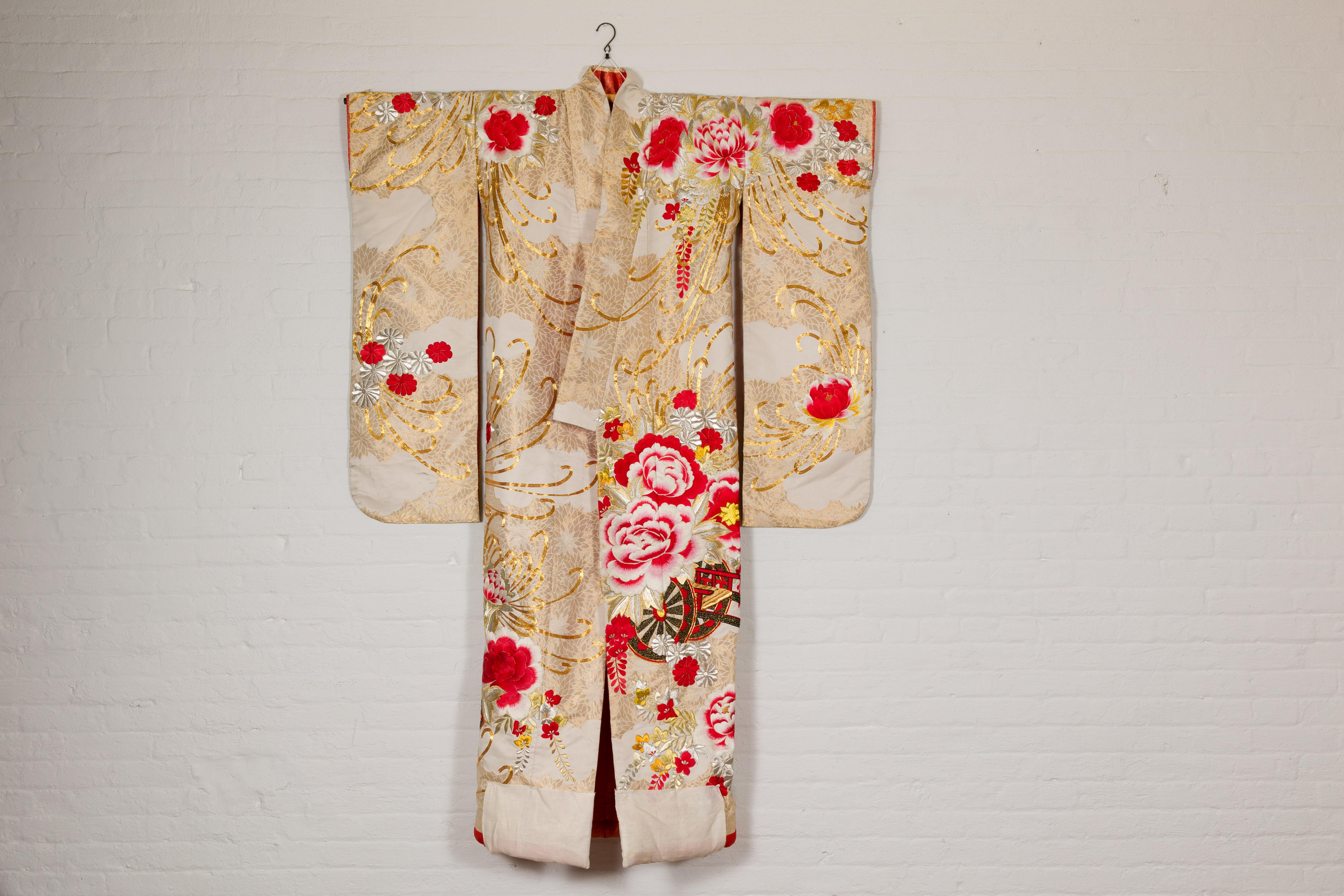A vintage Japanese Showa era handcrafted silk brocade woman's wedding kimono circa 1940 with intricate hand-embroidered details depicting large flowers and a cart. Steeped in cultural opulence, this vintage Japanese Showa era woman's wedding kimono