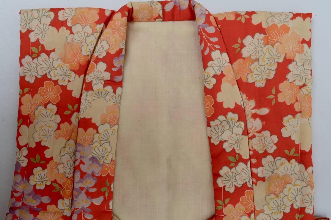 A Japanese child vest handmade from padded silk. The vest has an overall pattern of cherry blossoms and wisteria and would be worn for the spring festivals. In excellent condition.