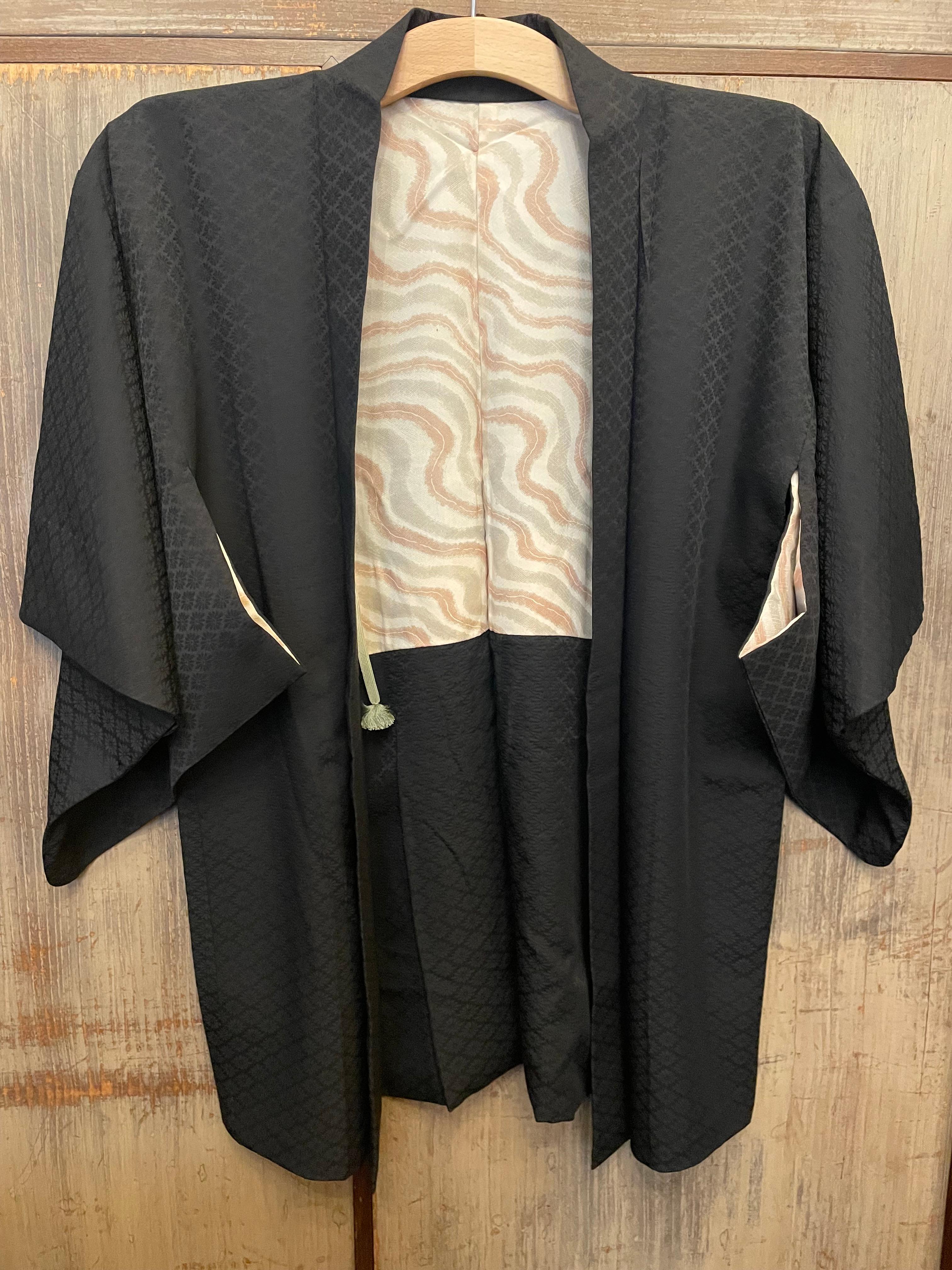This is a silk jacket which was made in Japan.
It was made in Showa era around 1980s.
This haori jacket has a family crest of  MaruniChigaiTakanoHaMon.

The haori is a traditional Japanese hip- or thigh-length jacket worn over a kimono. Resembling a