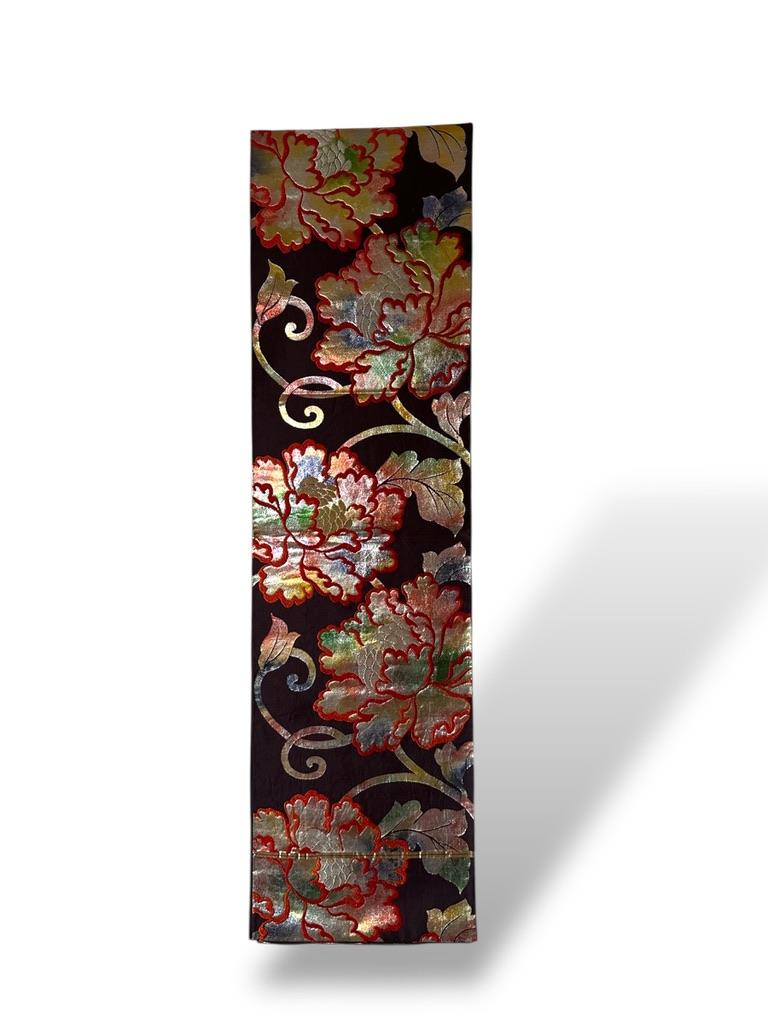 runner da tavola Obi in seta apanese con motivo di peonie
Giappone, XX secolo
Dimensioni: 440 × 32 cm

Questo lussuoso obi di seta è stato trasformato in un elegante runner da tavola. Tessuto con fili metallici scintillanti, presenta uno
