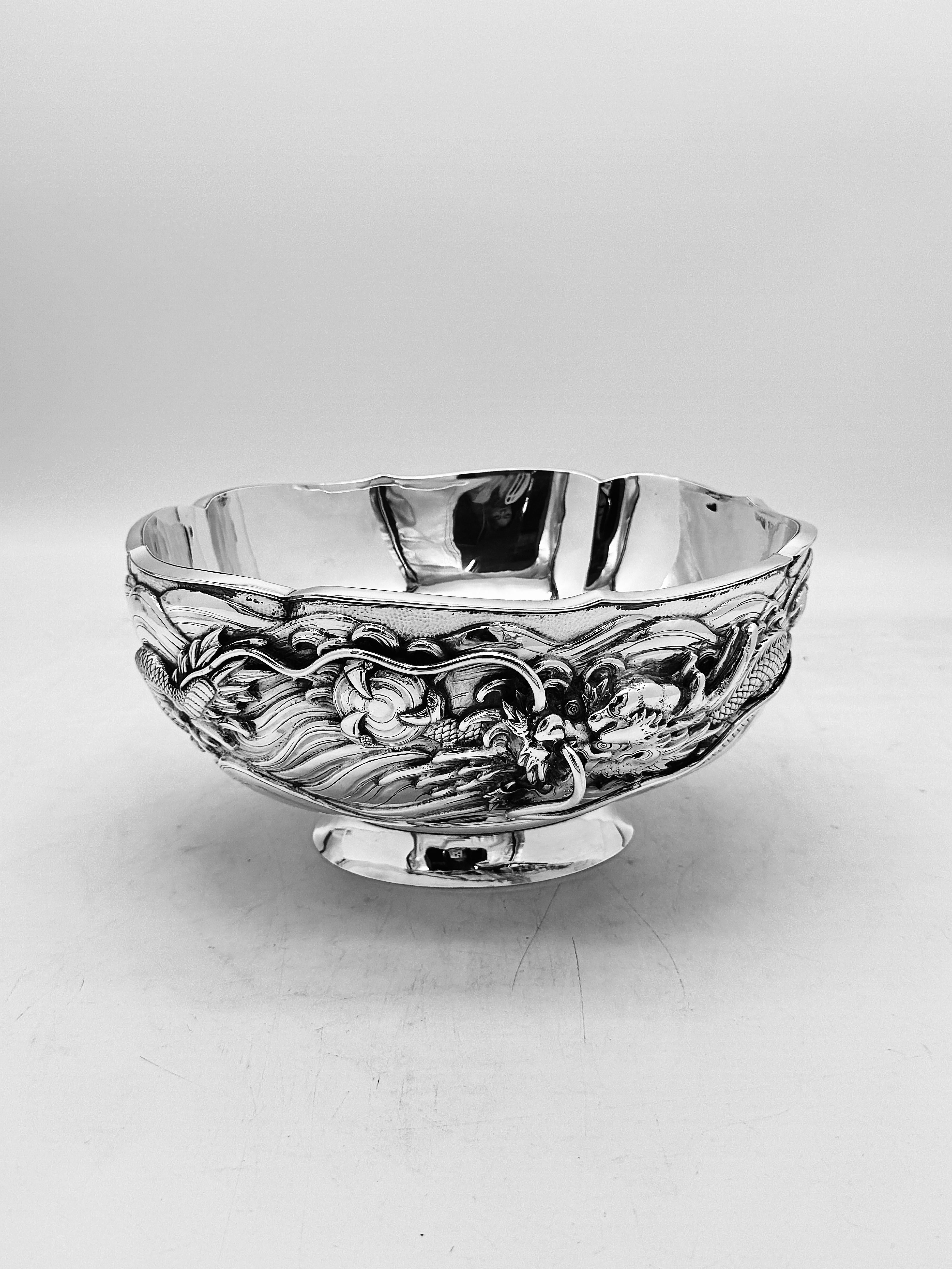 Japanese Silver Bowl, Meiji period (1868-1912)

A round, double-walled bowl with a wavy rim of beautiful design, the exterior finely embossed and chased in high relief with a three-clawed dragon amidst crashing waves, raised on a plain round base.