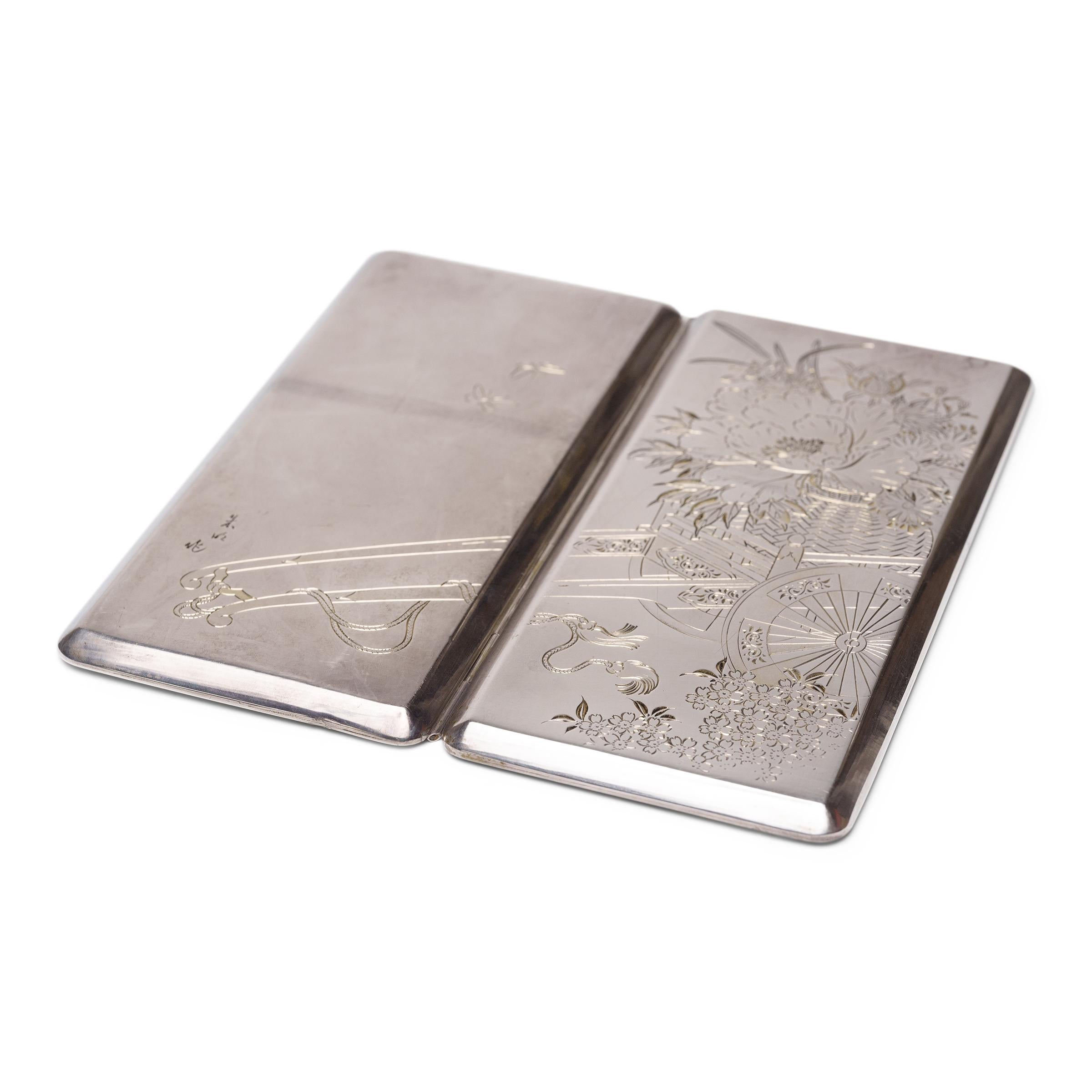 This engraved silver cigarette or billfold case exemplifies Japanese refinement in all crafts. Spanning both sides of the exterior is an elaborate design of a traditional flower cart pulling a woven basket of orchids, peonies and chrysanthemums - a