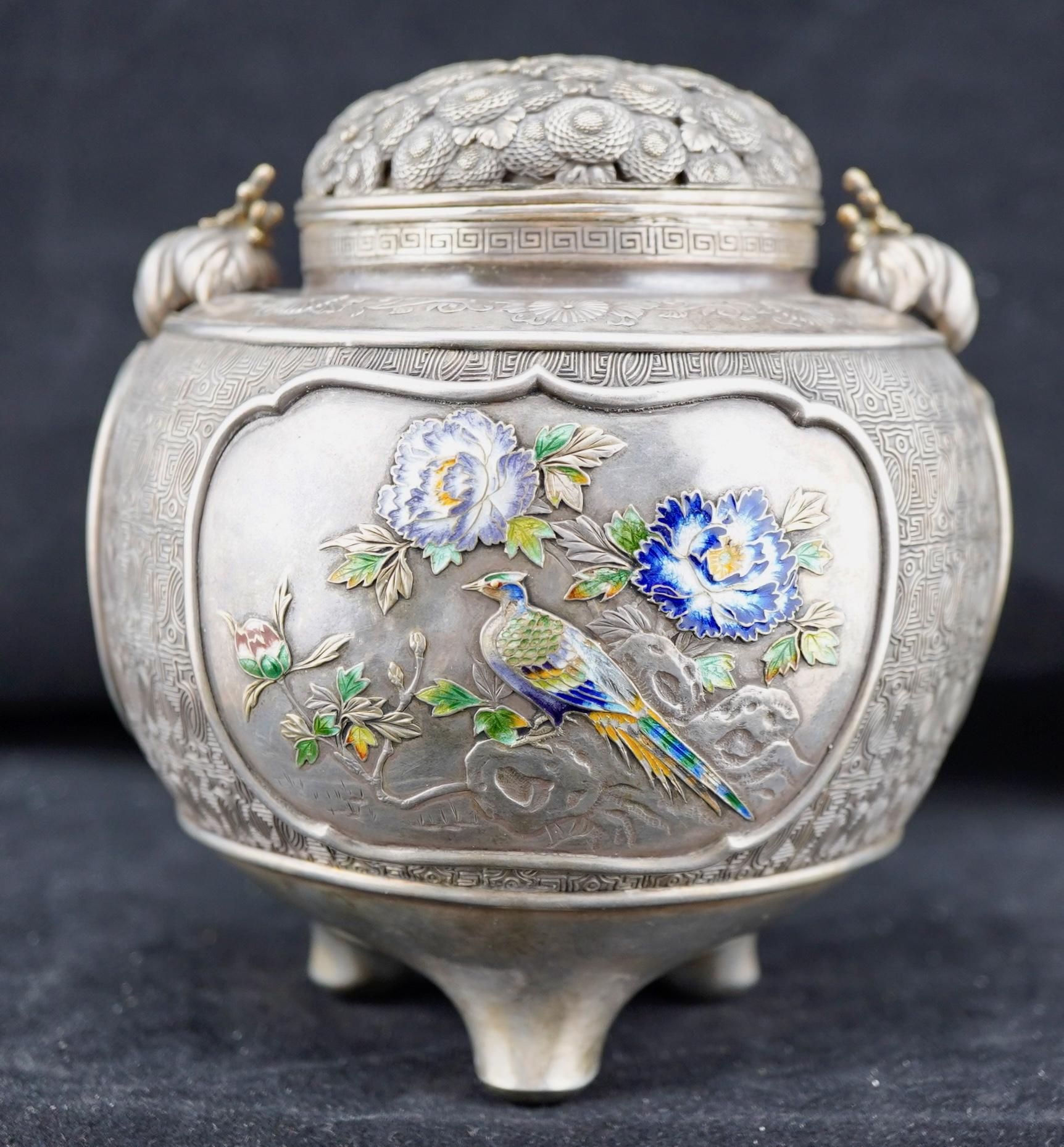 Japanese silver and enamel Incense Burner (Koro) Meiji era (1868-1912), late 19th century. The koro is set on tripod feet, The body decorated with three panels of birds and flowers worked in low relief and translucent enamels.  The body carved with