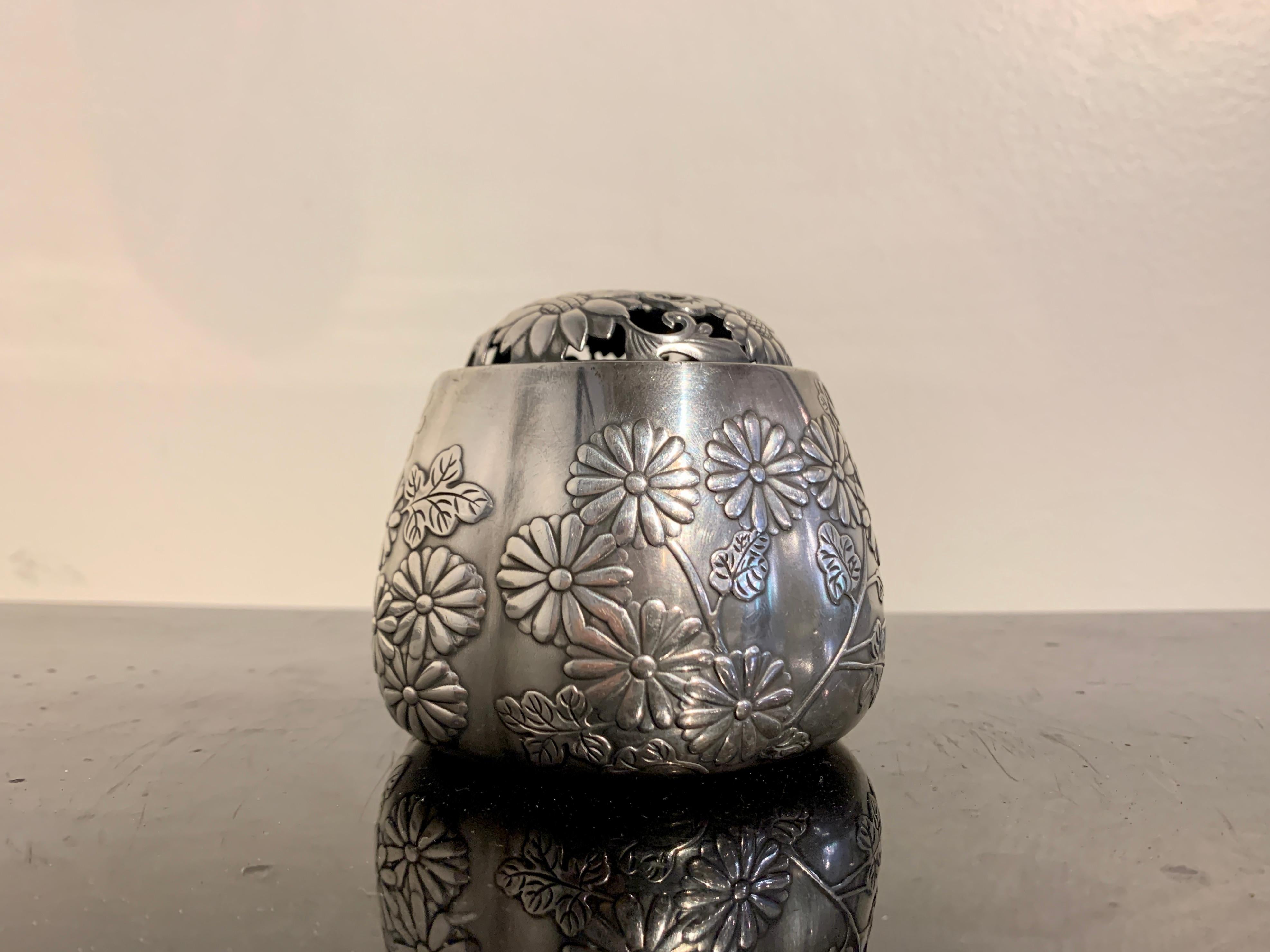 A lovely and luxurious Japanese silver incense burner of lobed melon form, akoda koro, marked jungin and signed Nomura, Meiji Period, circa 1900, Japan.

The silver koro, vessel for burning incense, takes on a traditional six lobed melon shape, a