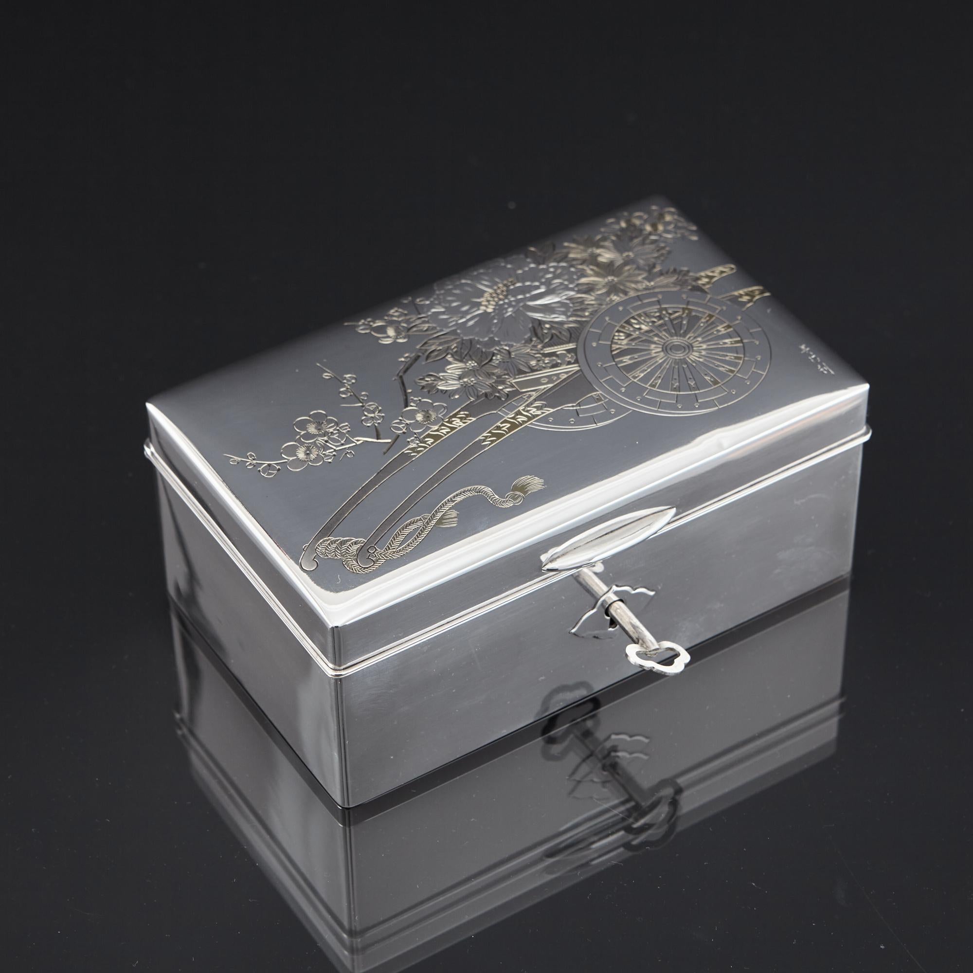 Charming first quality Japanese silver (950/1000) jewel box beautifully hand engraved with an image of a traditional wooden cart brimming with a profusion of chrysanthemums and cherry blossom - familiar Japanese artistic motifs - and delicately