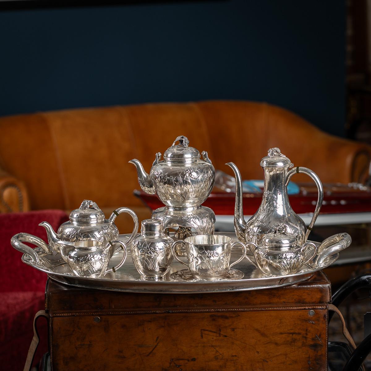 Antico servizio da tè e caffè in argento massiccio giapponese dei primi del Novecento, composto da otto pezzi su vassoio, di qualità eccezionale e magnifica, a doppia parete, con fiori di Iris in rilievo, eleganti manici a forma di C e coperchi