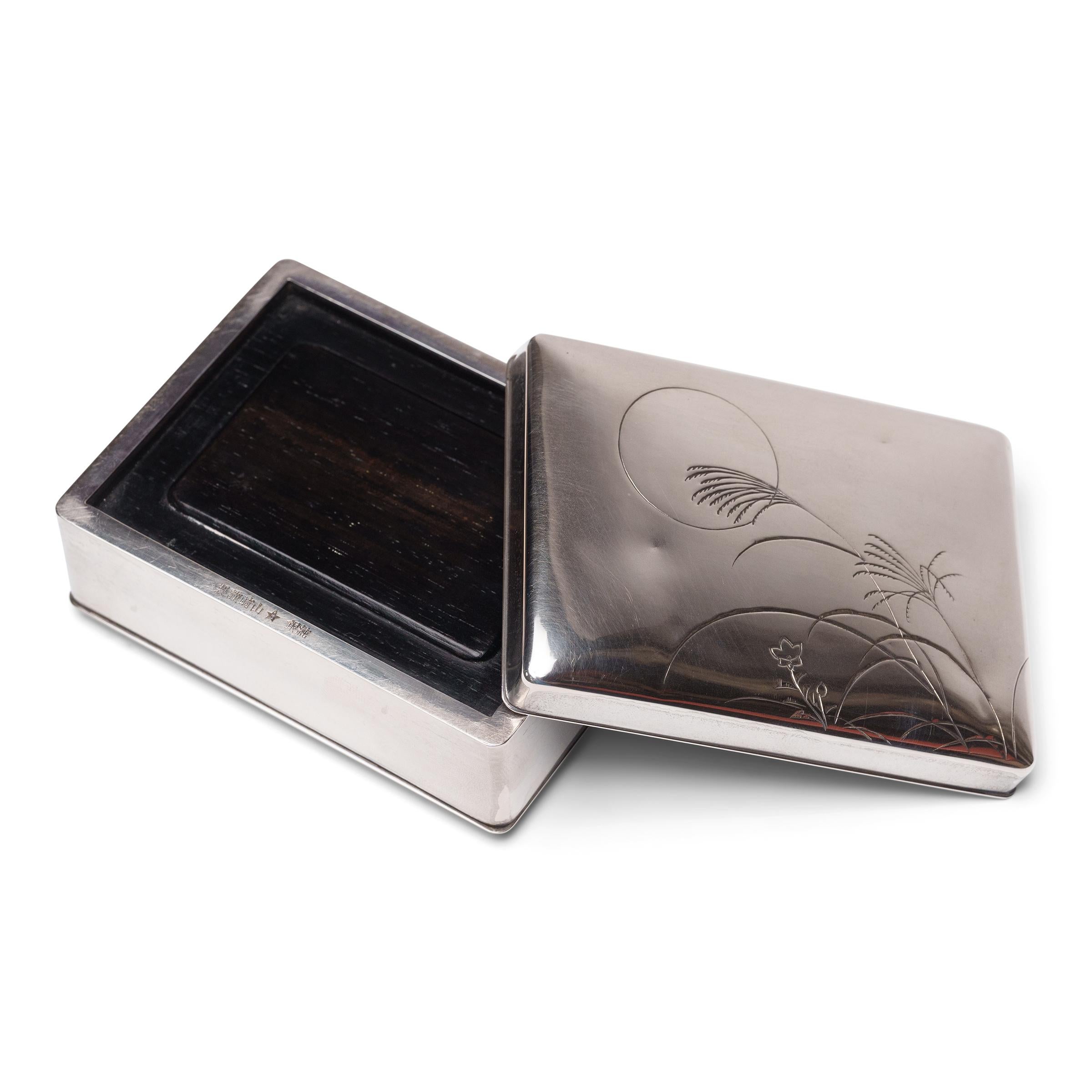 Questo portagioie del periodo Meiji esemplifica la raffinatezza giapponese in tutti i mestieri. Realizzata in argento con un interno in legno duro, la piccola scatola ha una forma rettangolare pulita con angoli arrotondati e un sottile labbro nel