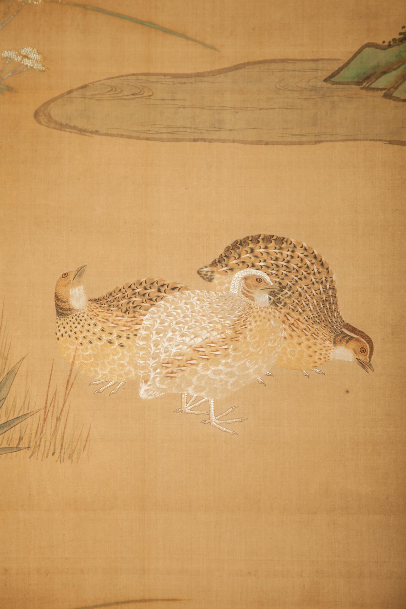 Quails roaming a field with wild flowers and grasses next to a meandering stream. Mountain peaks in the distance. A serene landscape. Soft mineral pigments, ink, and gold dust on silk with a silk brocade border. Signature and seal read: Fujiwara