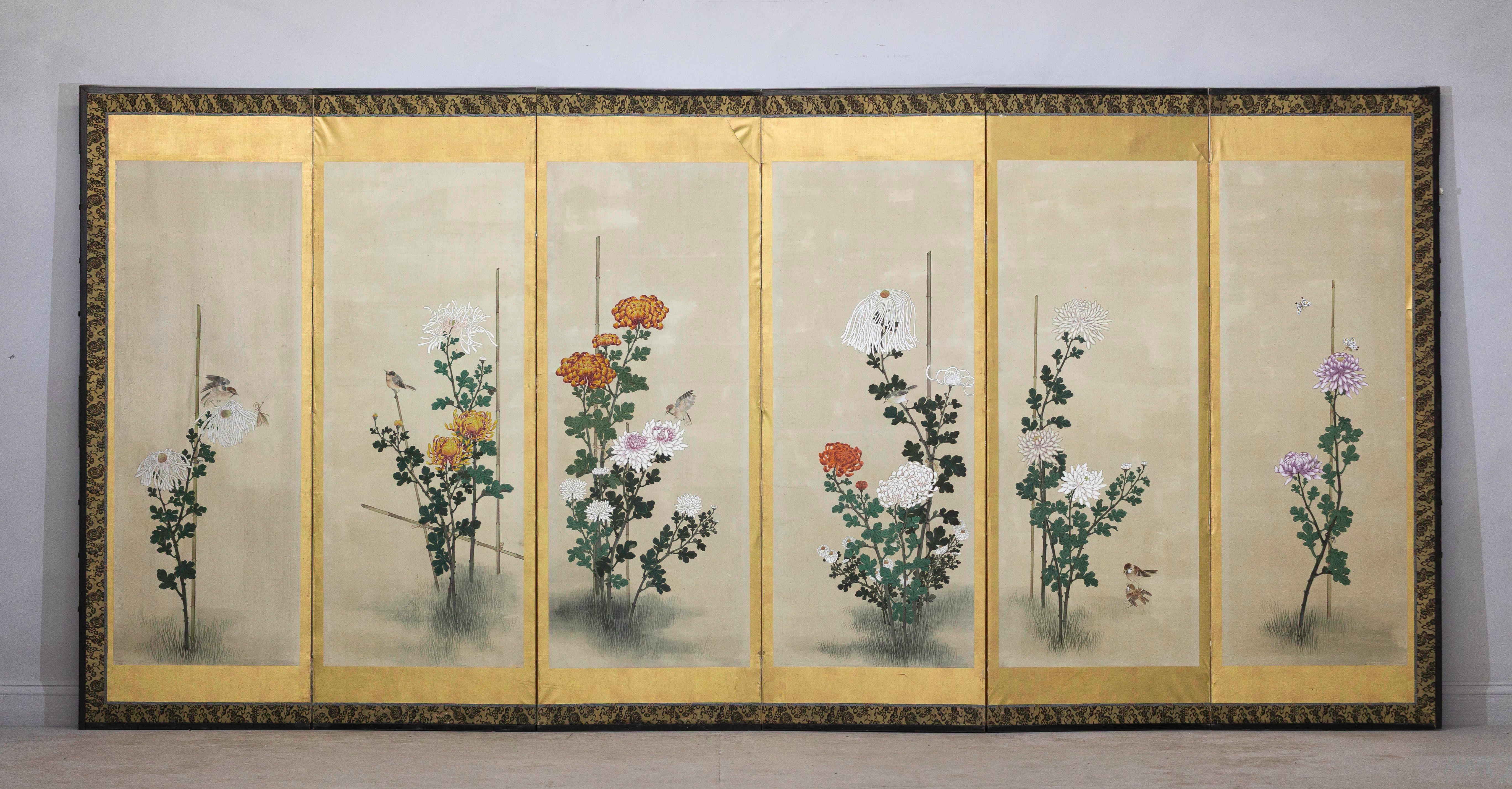 Un raffinato paravento giapponese a sei pannelli dipinto a mano con una graziosa composizione di crisantemi stagionali e piccoli uccelli. Probabilmente risalente all'inizio del XX secolo, durante il periodo Taishō (1912-1926), questa composizione