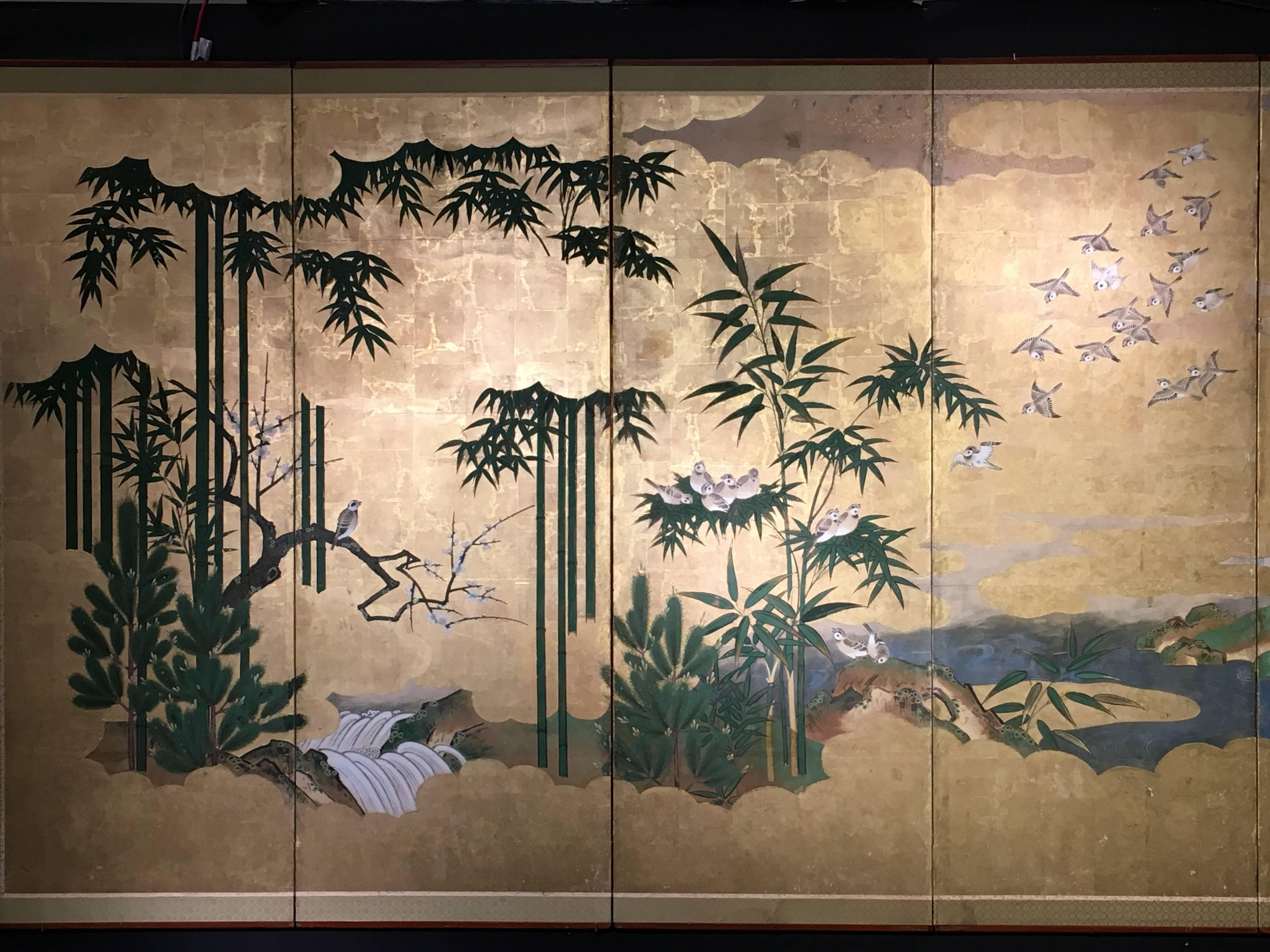A beautiful and elegant Japanese Edo period six-panel painted screen, byobu, 18th-19th century. The screen featuring a flock of sparrows descending from billowing golden clouds to roost in a bamboo grove. A rushing white water stream flows through