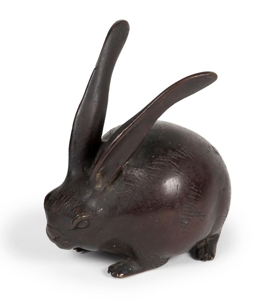 Small round hare in bronze with dark brown patina, standing on its four legs.
In Japanese, the hare and the rabbit are referred to by a single word: usagi. The animal is one of the twelve animals of the zodiac in Sino-Japanese astrology. It also