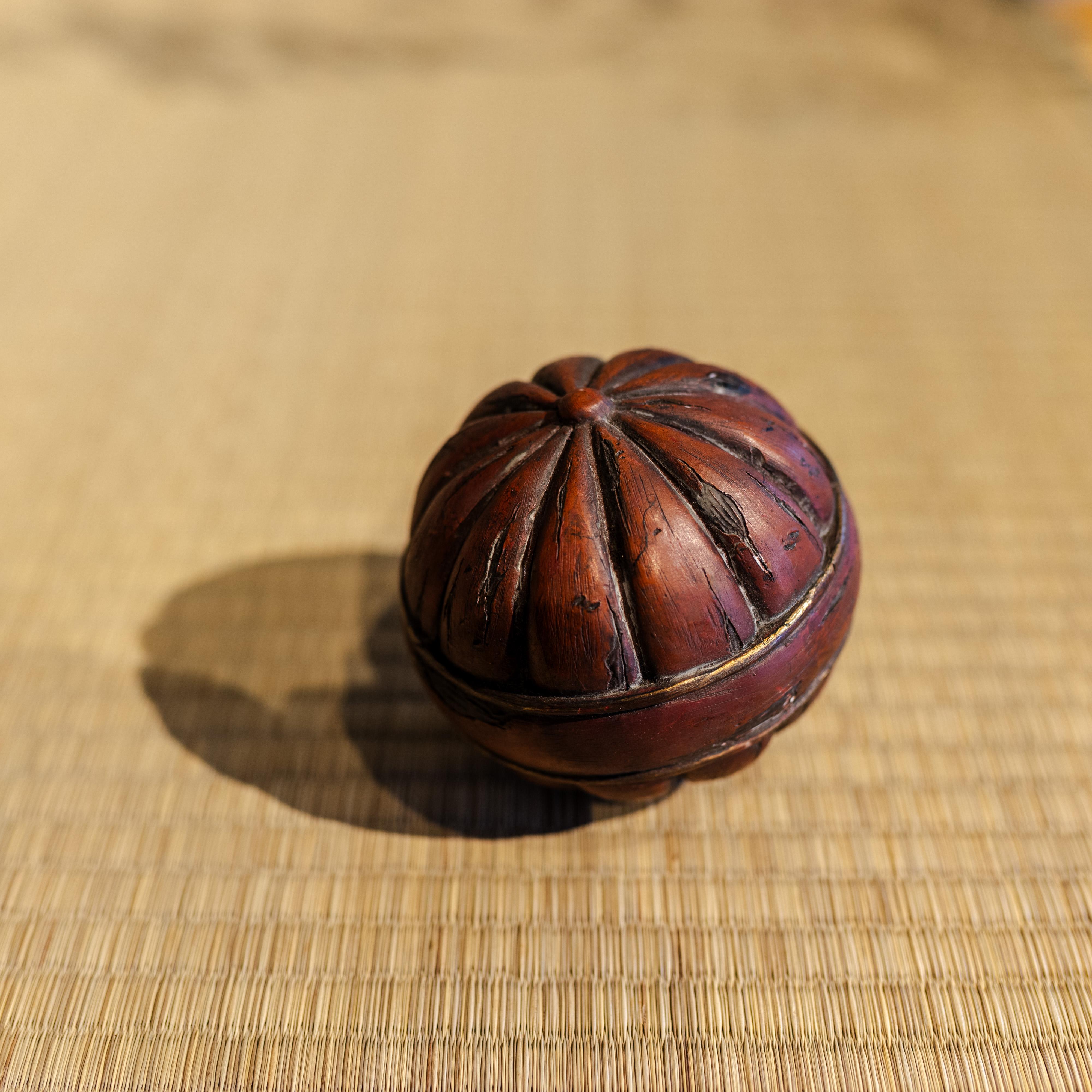 Ein charmantes antikes japanisches Holzkugelspielzeug, handgeschnitzt mit einem auffälligen radialen Design. Gefertigt aus reichlich getöntem Holz mit wunderschön gealterter Patina, verkörpert es sowohl die Schlichtheit als auch die ruhige