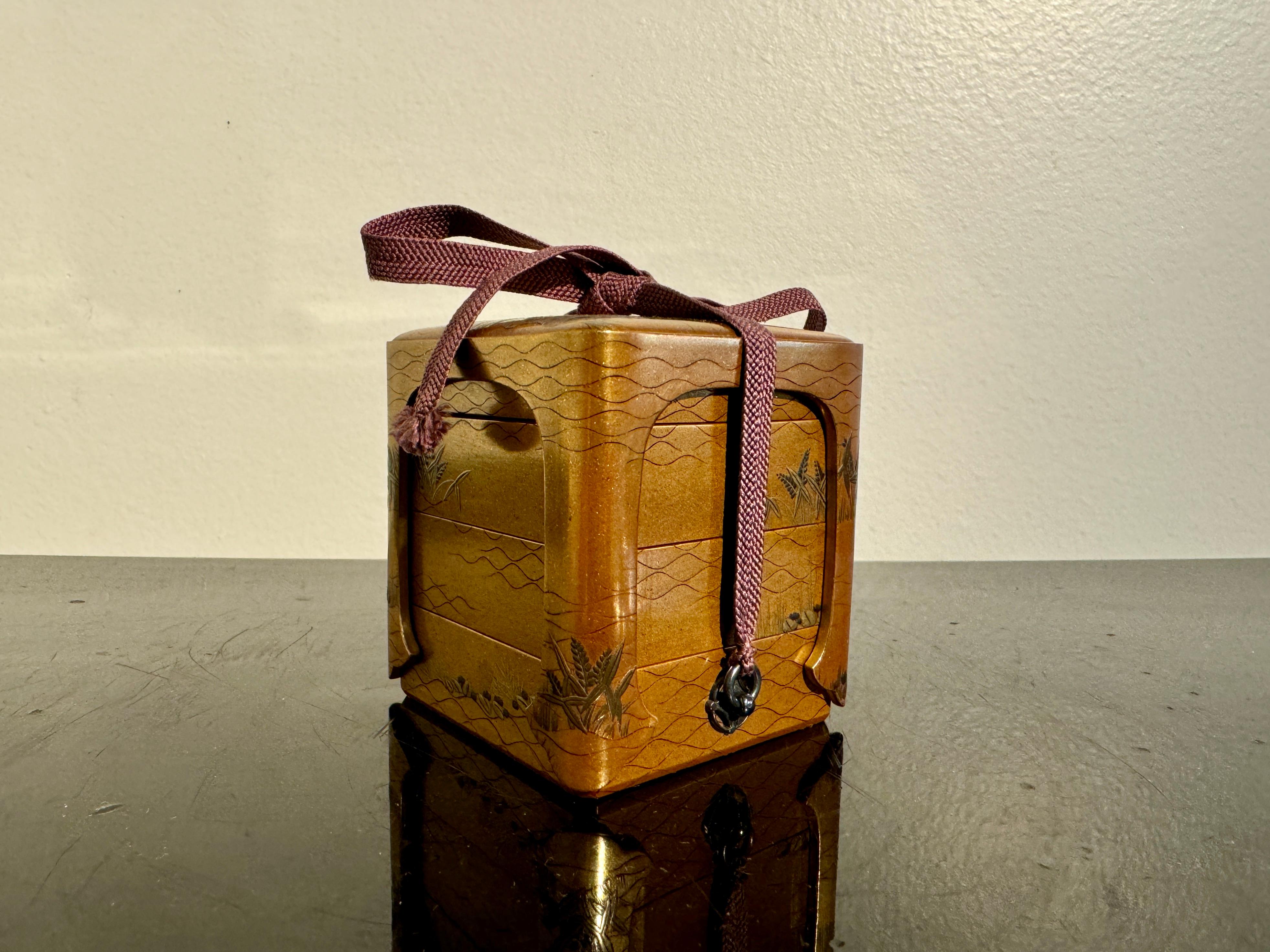 An exquisite small Japanese maki-e lacquer stacking box for incense and accessories, ju-kobako, late Edo or early Meiji Period, mid 19th century, Japan.

Crafted in maki-e lacquer and formed as a miniature jubako, the stacking box is comprised of