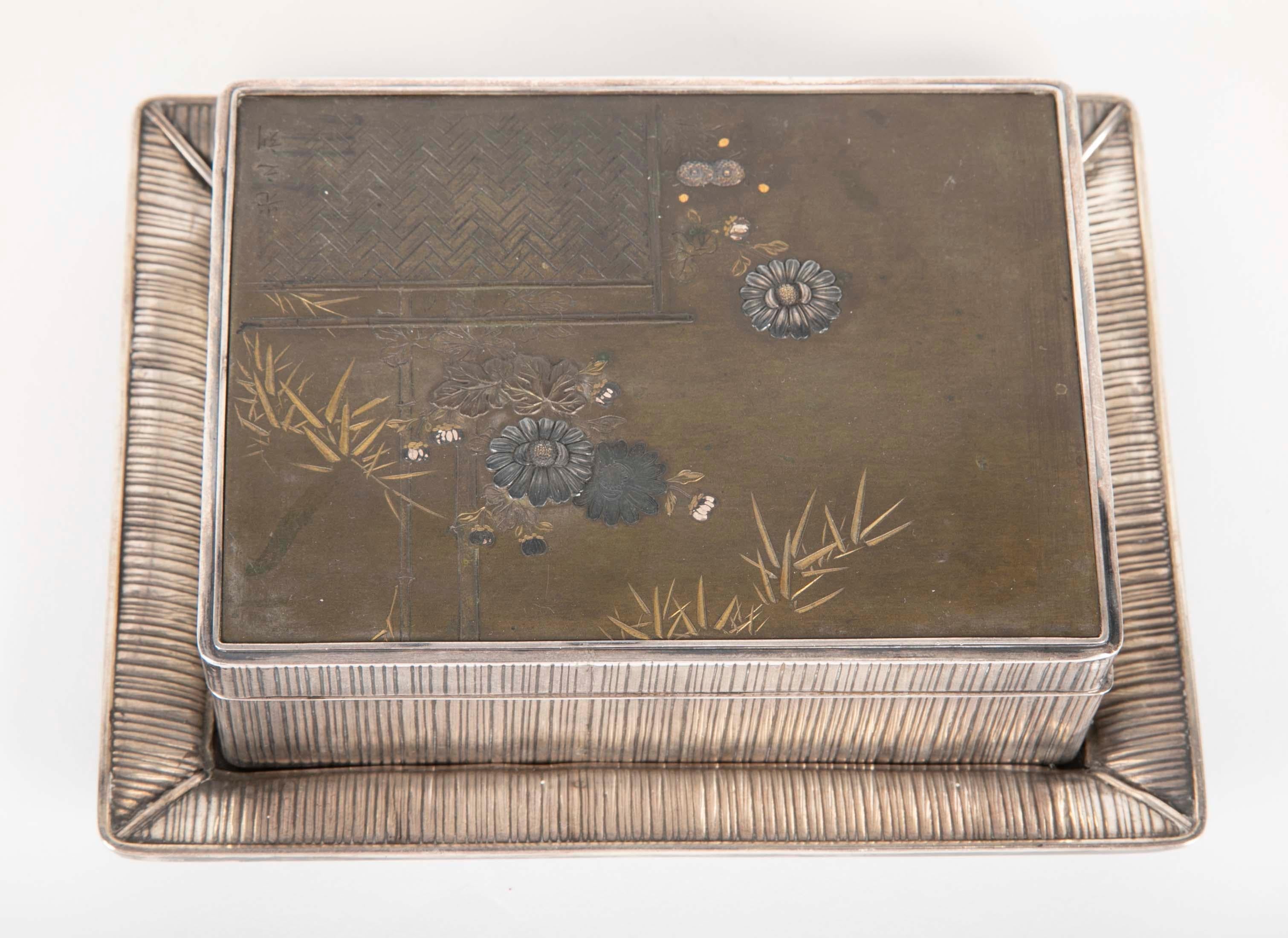 Eine japanische Dose aus Sterlingsilber und gemischtem Metall mit Tablett über Holz. 

  