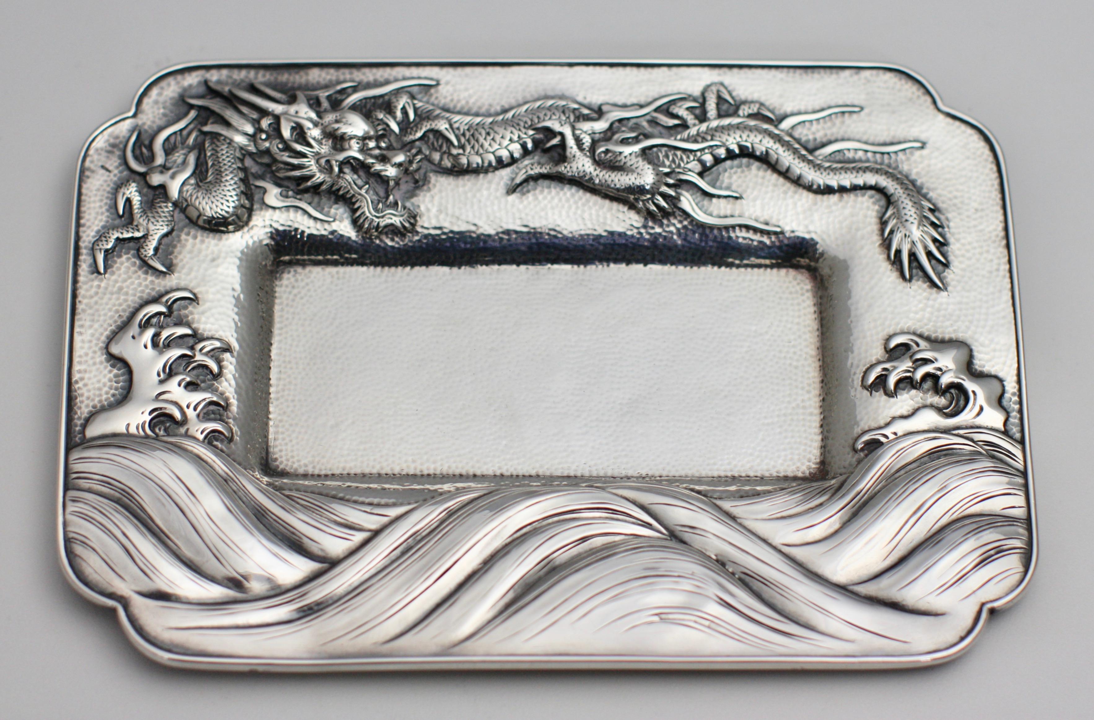 Japanese sterling silver pan tray
Meiji Period (1868-1912).
Stamped Arthur & Bond, Yokohama, Sterling.
Chased in relief with a dragon above waves.
Measures: Width 4 3/8 in. (11.11 cm.)
Length 6 3/8 in. (16.19 cm.)
Provenance: Formerly from an