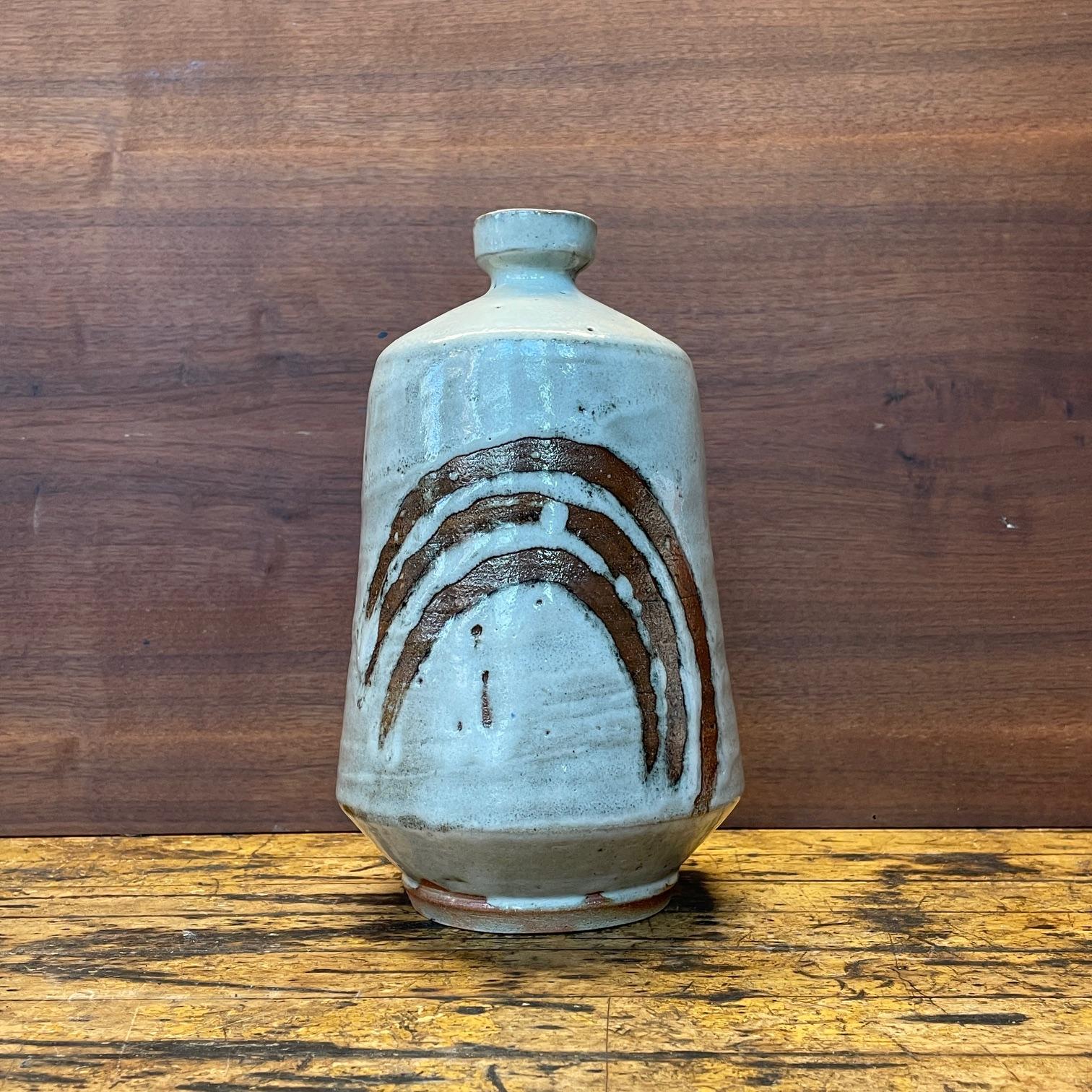 Grand vase en forme de bouteille avec des stries en arc de cercle. Conserve le Label OMC. Quelques petits éclats à la partie inférieure du pied/de la bordure.