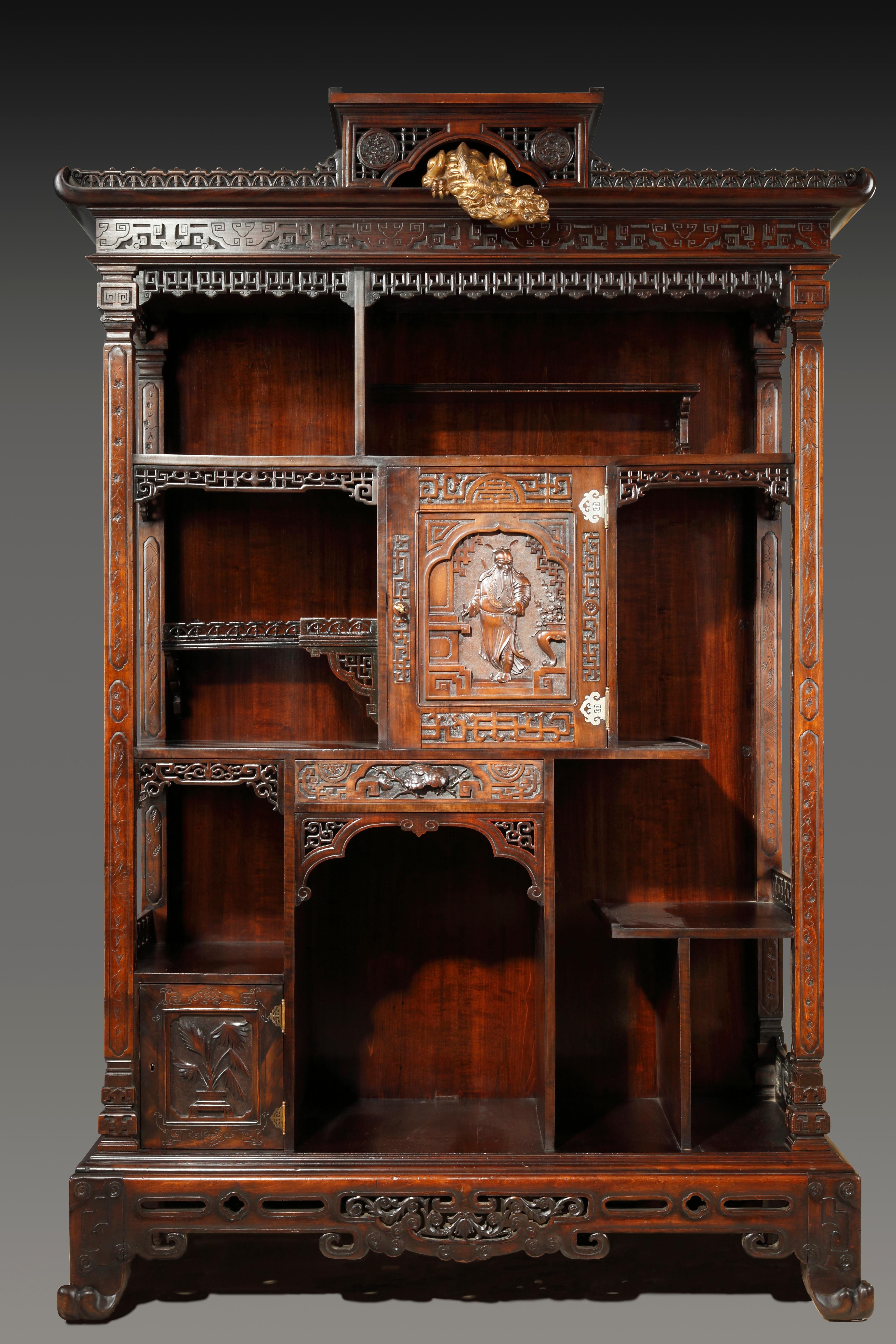 Beautiful Japanese style cabinet attributed to Viardot, made in stained carved wood, composed of asymmetrical niches and shelves underlined with openwork friezes. It opens to a drawer and two doors adorned with foliage and a Samouraï figure. Four
