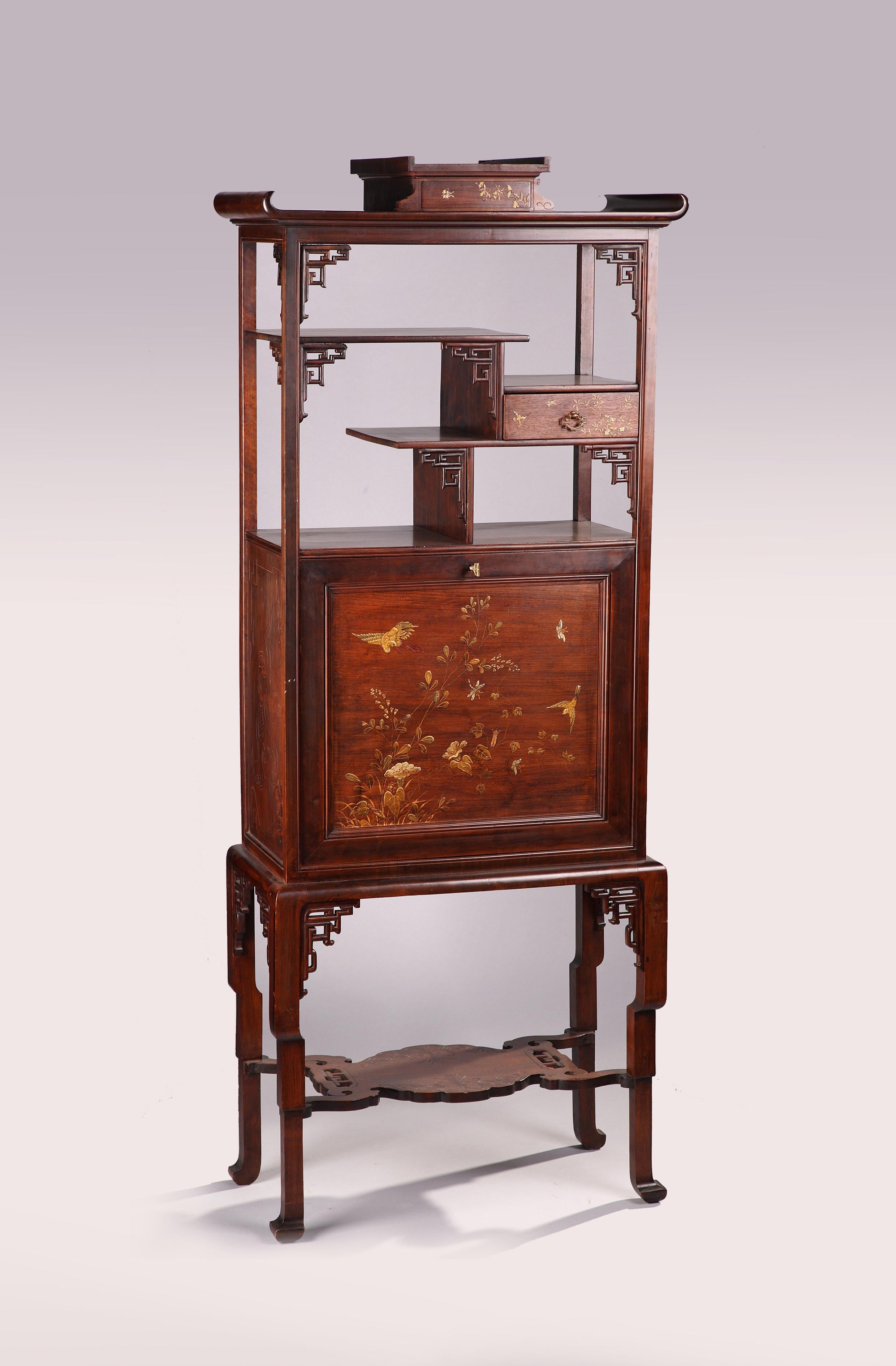 A Japanese style carved wood cabinet, with a painted decor imitating Japanese lacquer, ornamented with flowers, birds and butterflies. Opening onto two drawers and a paper filer, the upright-secretary door is also fitted with red velvet. Surmounted
