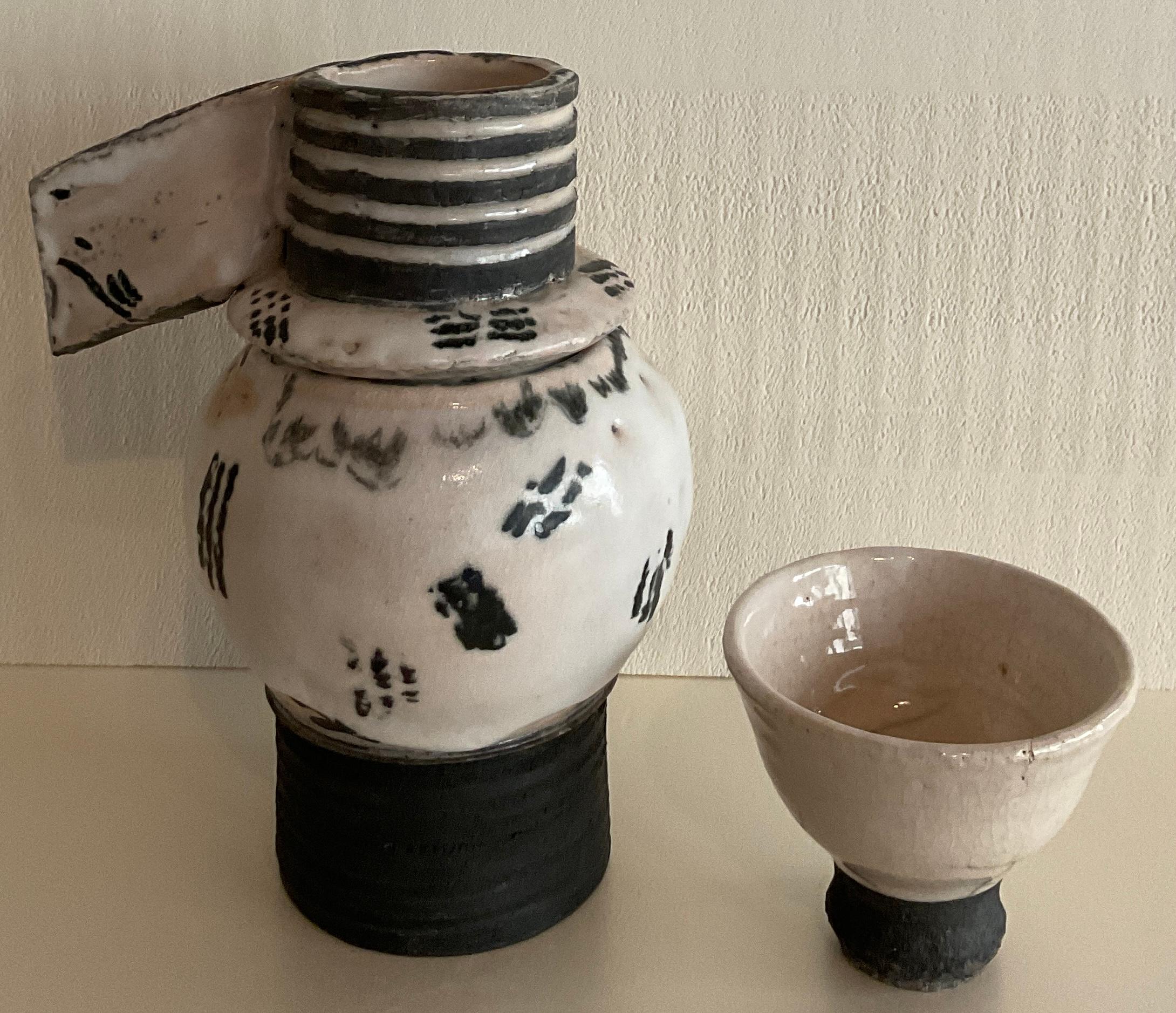 A very nice contemporary Japanese style ceramic tea pot and tea cup. 

This zen teapot has three parts that allow for perfect tea brewing. 
Glazed. 
Ceramic artist, unknown. 

Measures: 7