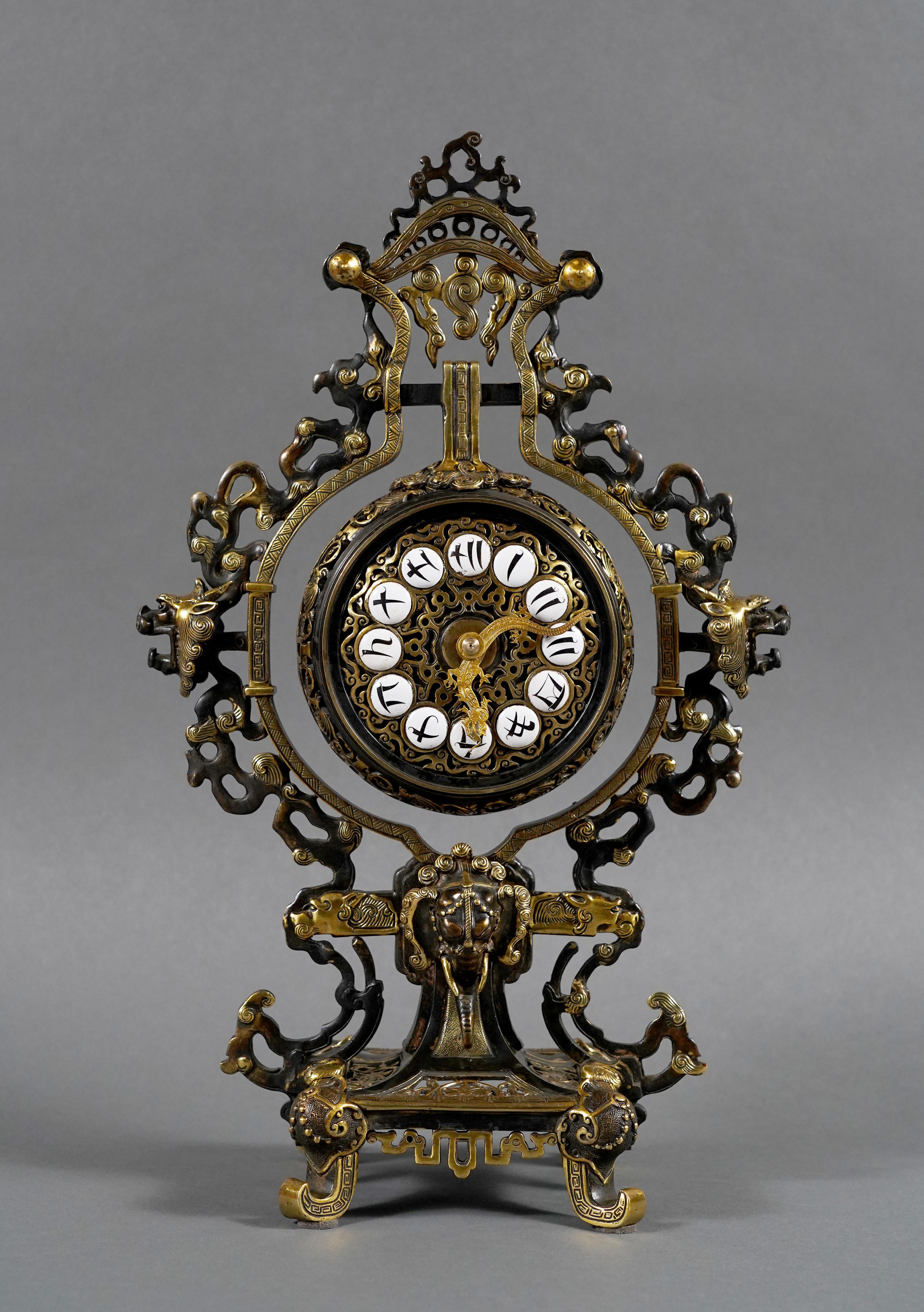 Rare Japanese clock in double patina bronze with suspended dial.
The portico and dial, with calligraphic Kanji numerals complemented by hands featuring an undulating dragon, are decorated with clouds with dragon heads and sacred pearls.
The whole is