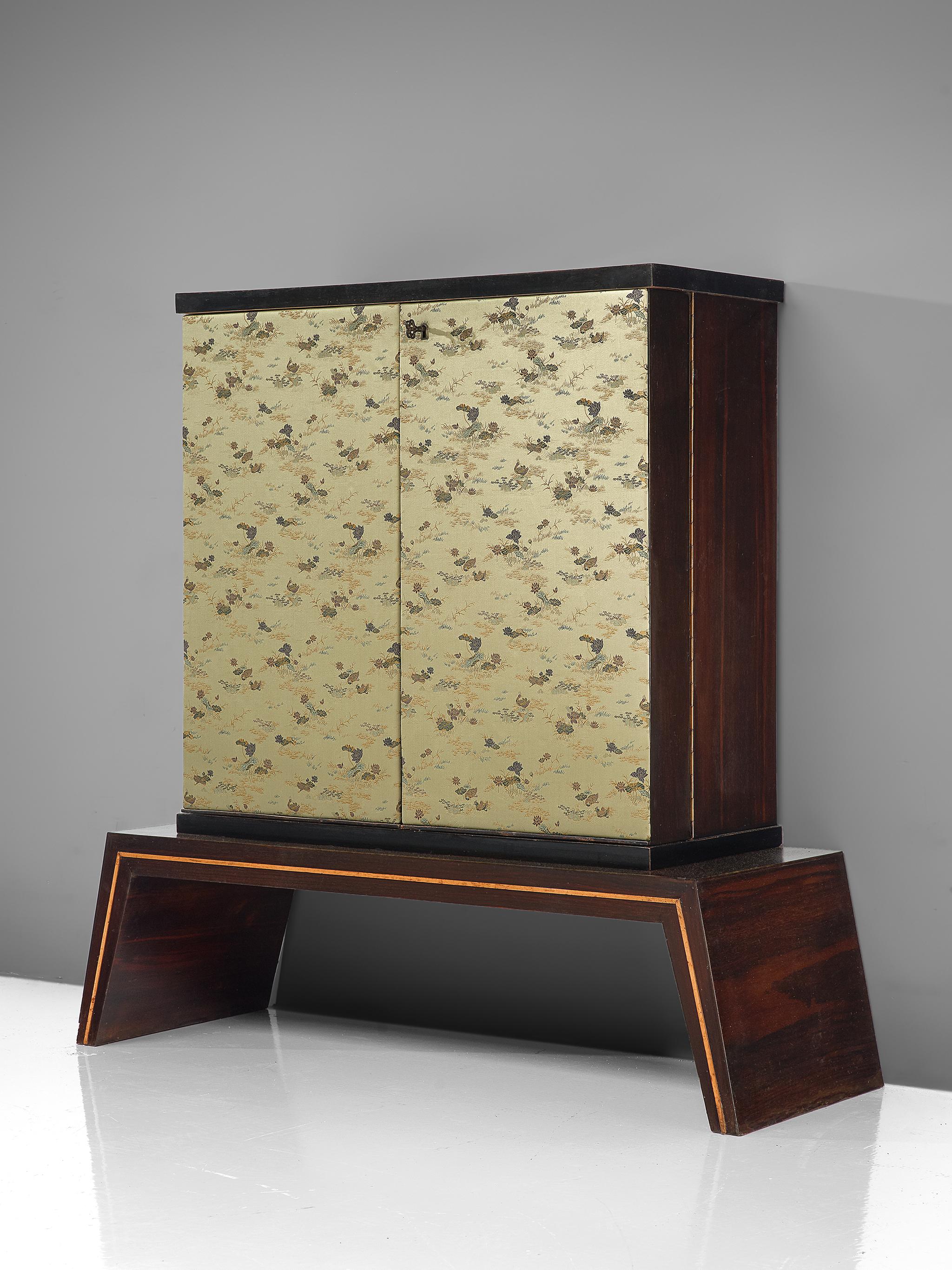Dry bar cabinet, fabric, wood, and mirror, Italy 1950s.

This exquisite dry bar is illuminated and has a mirror interior with storage facilities. The front of the cabinet is covered with a Japanese inspired silk fabric which is still original. The