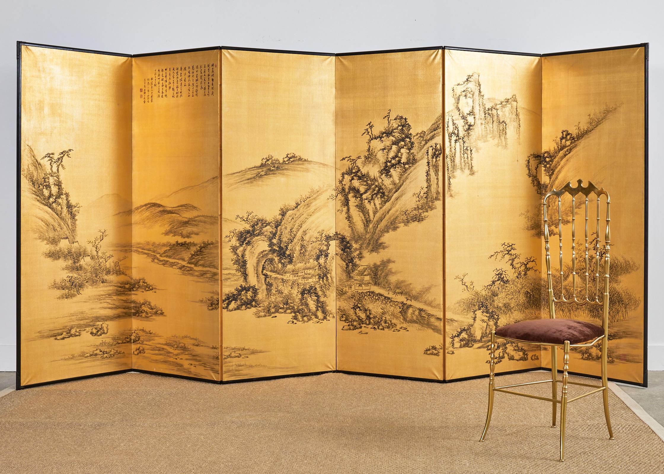 Impressive Japanese style Showa period six-panel byobu screen featuring a serene Chinese mountain landscape along a waterway over a dramatic gilt background. The painting is accompanied by a long poetic colophon in Chinese signed by the