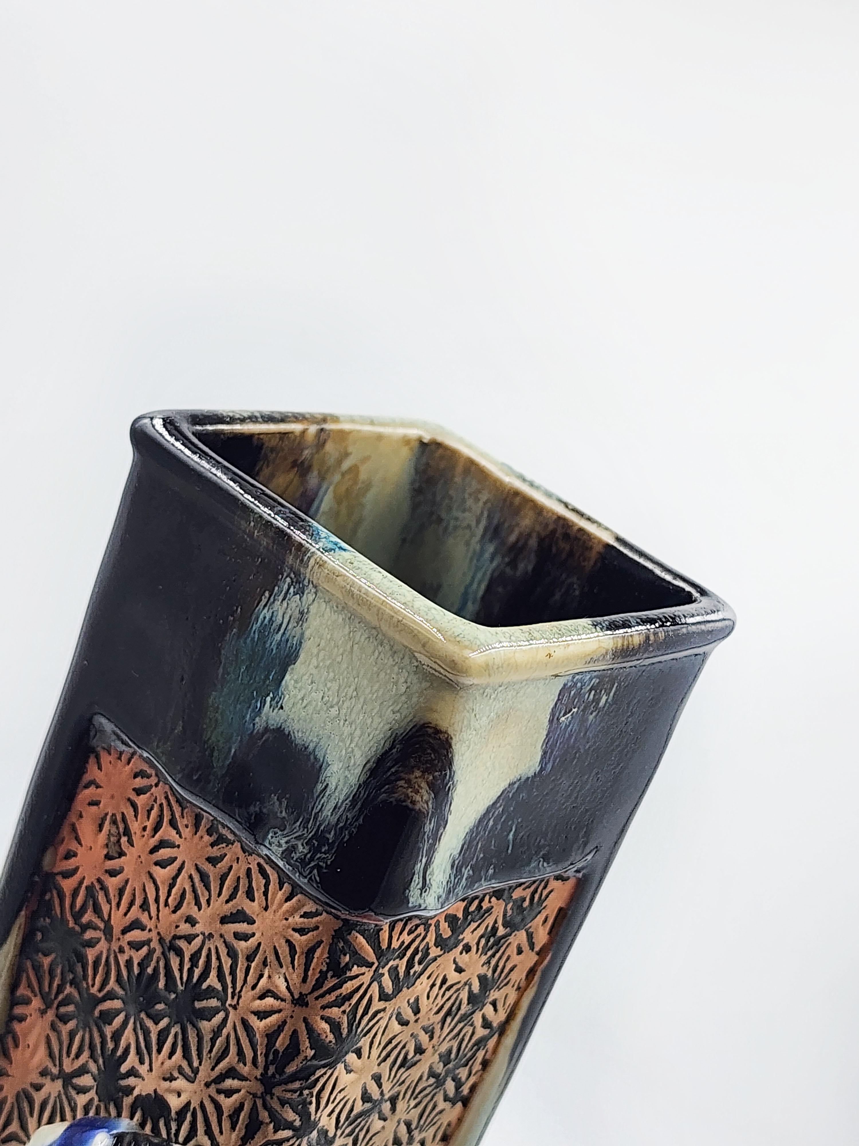 Vaso in ceramica giapponese Sumida Gawa
Vaso in ceramica giapponese di Sumida Gawa decorato a rilievo con tre dame, due delle quali sono serve, con un reticolo al centro e un effetto iridescente sulla ceramica. La ceramica deve il suo nome al fiume