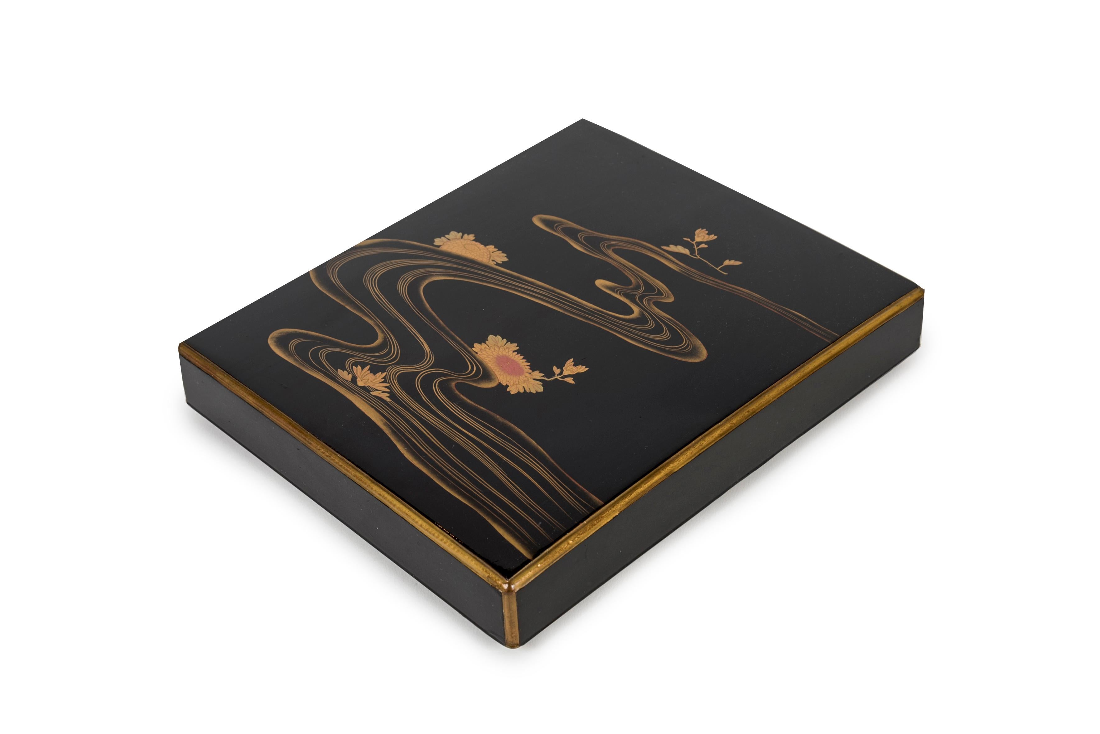 Suzuribako box (empty) in black lacquer. Gold maki-e decoration of a river bordered by peonies, one with red highlights. The edges of the lid are in gold lacquer. Nashi-ji interior.