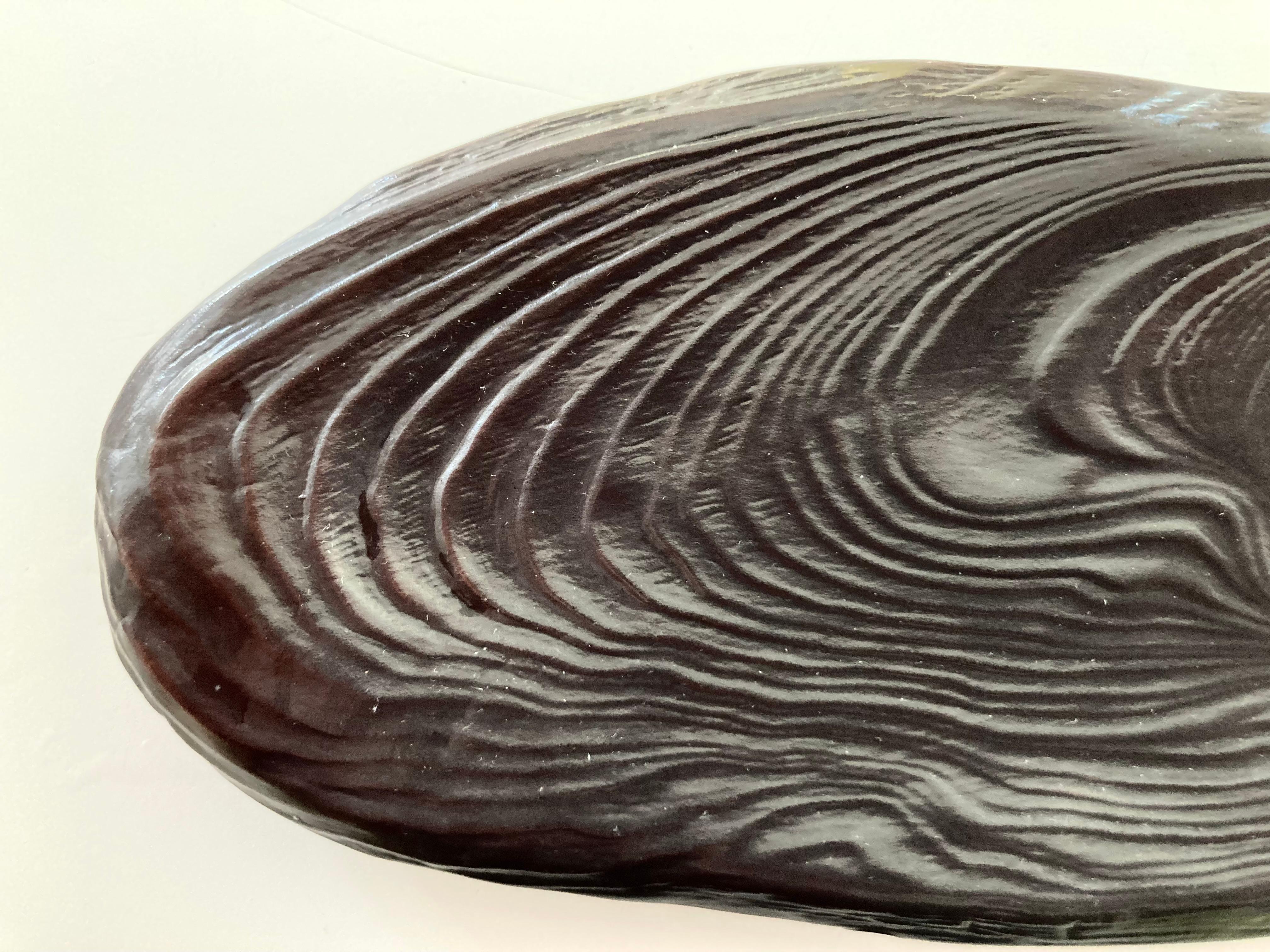 A finely crafted Japanese glazed Porcelain Sweet Dish in the form of a natural wood slab. In a deep Chocolate Brown glaze with good weight and bearing the marks of a wood slab with an off center knot surrounded by growth rings in raised pattern.