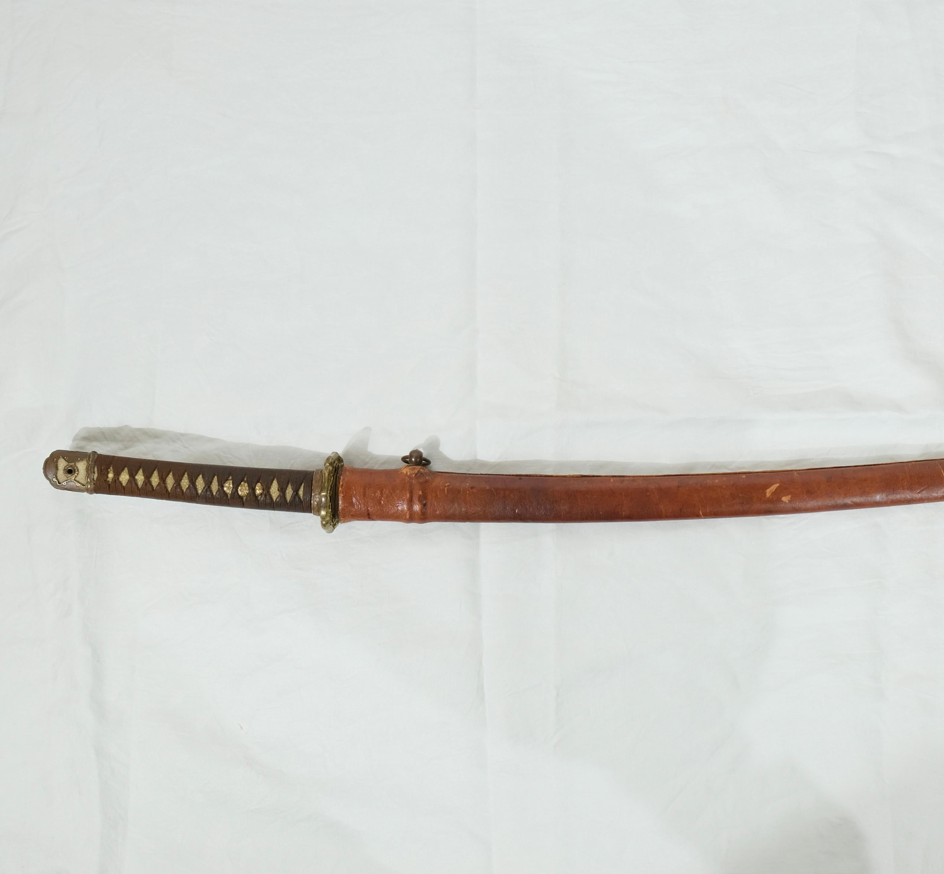 A Japanese sword, army-mounted from the 19th c. The blade with signature.Fuchi Kashira of gilt copper and the handle with skin of ray under the twisted brown threads.