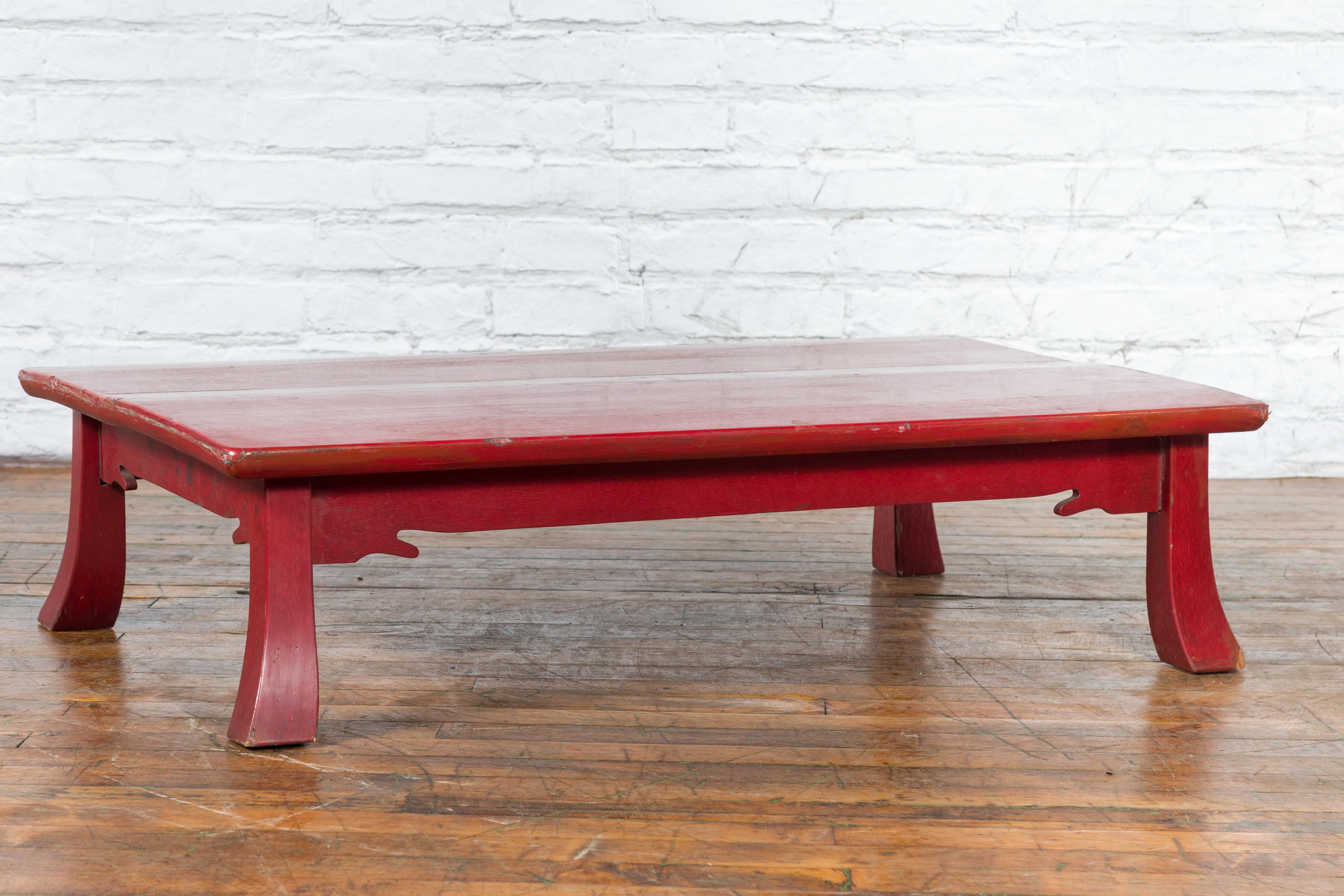 A Japanese Taisho period coffee table from the early 20th century, with red lacquer, textured effects, splaying legs and carved apron. Created in Japan during the Taisho period which ran from 1912 to 1926, this small coffee table features a