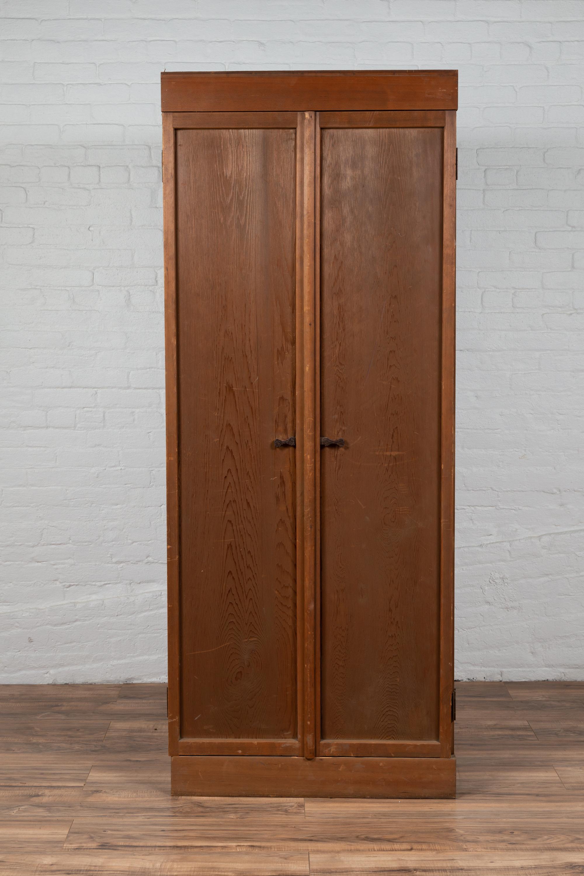 A Japanese Taisho period hinoki wood armoire from the early 20th century, with rare design and folding doors. Born in Japan during the early years of the 20th century, this hinoki wood armoire features two slender doors that fold outwards in an