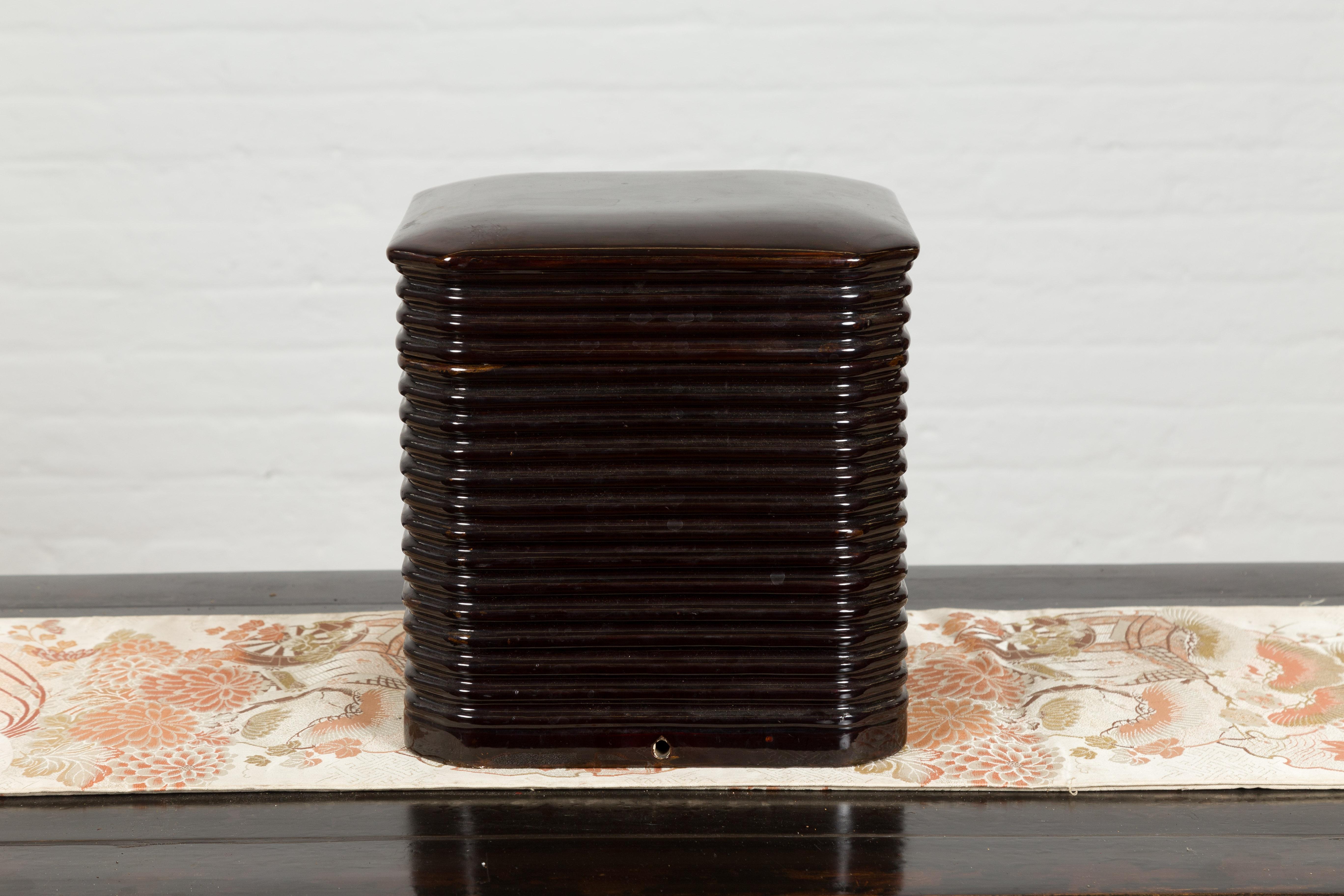 A Japanese Taisho period black lacquer box from the early 20th century with reeded patterns and lid. Created in Japan during the Taisho period, this black lacquered lidded box features a simple square shaped silhouette accented with canted corners