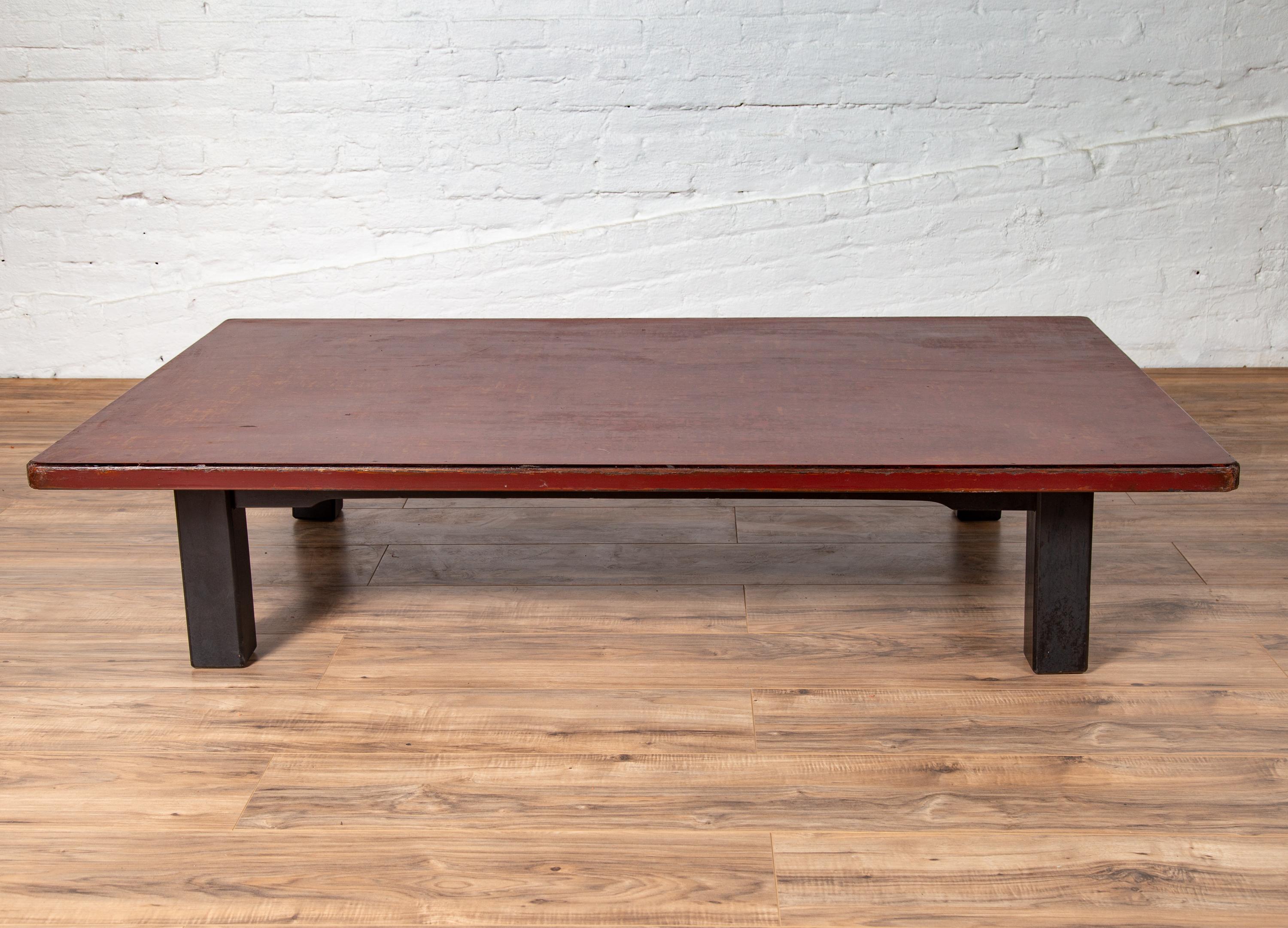 A Japanese Taisho period coffee table from the early 20th century, with Negora lacquer and black legs. Born in Japan during the first quarter of the 20th century, this charming coffee table was originally found in a coffee shop (you will indeed