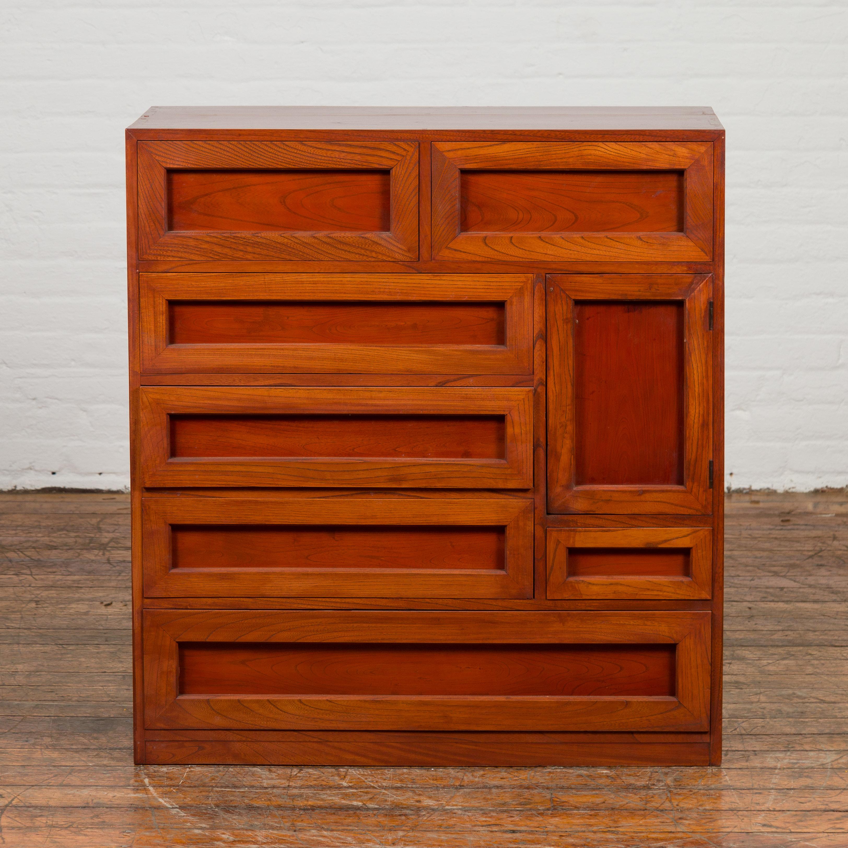 A Japanese Taisho period keyaki wood multi drawer side chest from the early 20th century, with recessed panels and warm patina. Created in Japan during the early years of the 20th century, this keyaki wood chest features seven drawers with darker