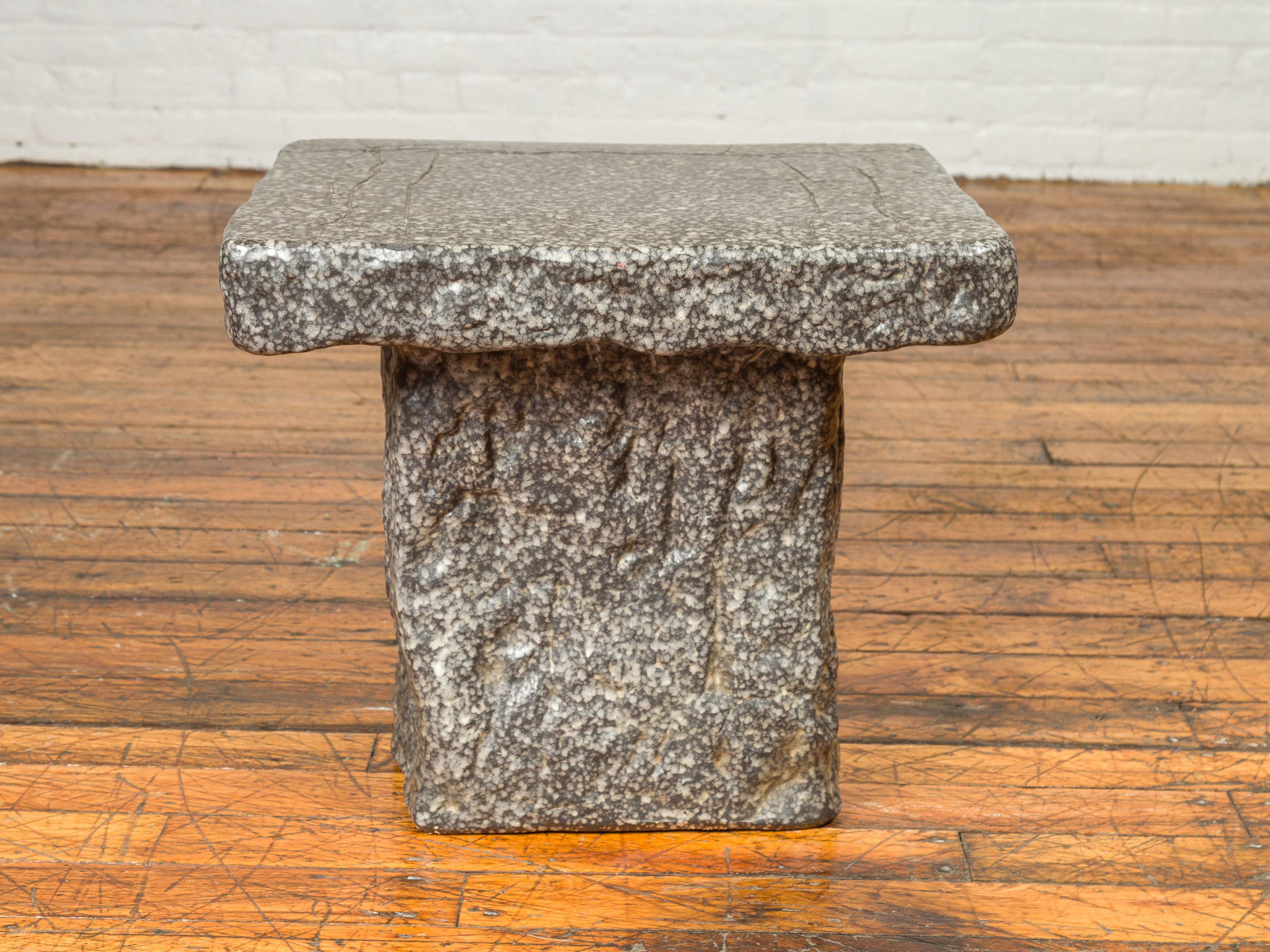 A Japanese Taisho period exterior stone garden seat from the early 20th century, with rustic appearance. Crafted in Japan during the first quarter of the 20th century, this Taisho period garden seat features a rectangular seat overhanging a